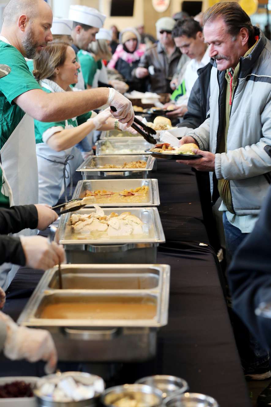 The Miller family, Larry H. Miller Sports & Entertainment employees and select Salt Lake City Stars players serve food at the 19th annual “We Care - We Share” Thanksgiving Dinner for local homeless and low-income individuals at Vivint Smart Home Arena on Monday, Nov. 20, 2017. (Photo: Scott G Winterton, KSL)