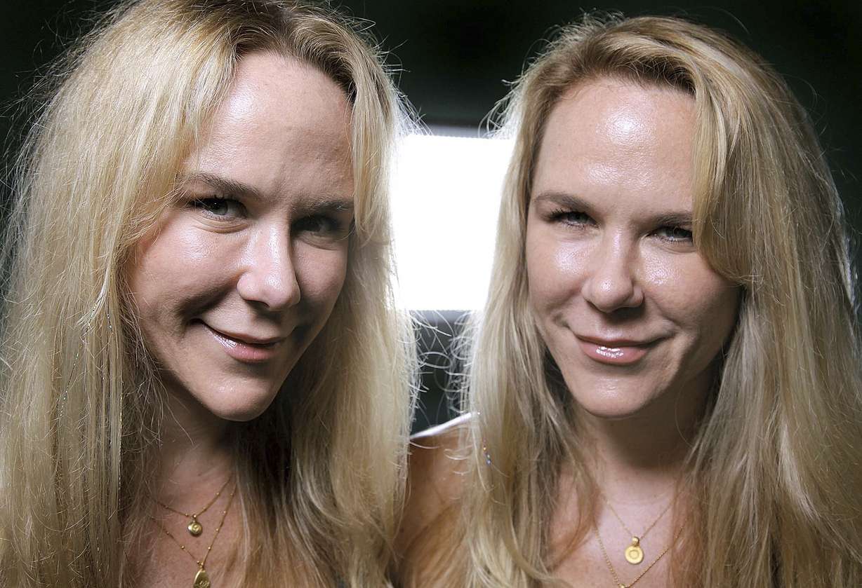 In this Oct. 12, 2011, file photo, Anastasia, left, and Alexandria Duval, known as Alison and Ann Dadow before they changed their names, stand in the window of their yoga studio in West Palm Beach, Fla. The attorney defending a woman accused of deliberately driving off a Maui, Hawaii cliff and killing her identical twin says prosecutors misled a grand jury that indicted her. (Thomas Cordy, Palm Beach Post via AP, File)