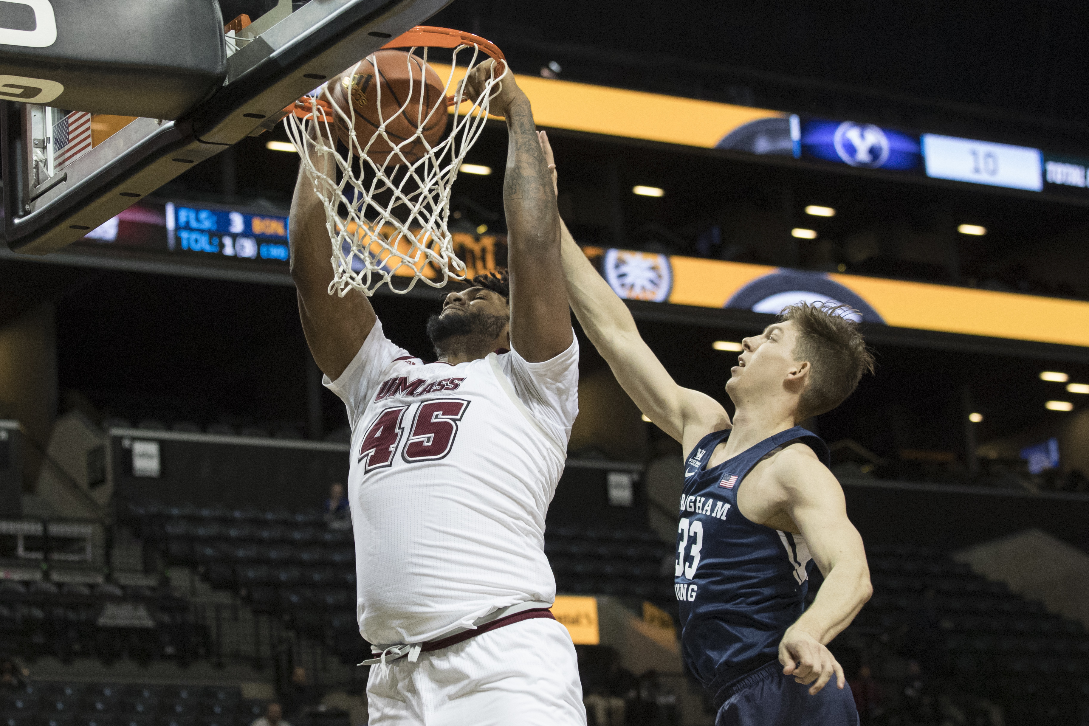 UMass center Rashaan Holloway (45) dunks /past BYU forward Dalton Nixon (33) during the first half of an NCAA basketball game, Saturday, Nov. 25, 2017, in New York. (AP Photo, Mary Altaffer)