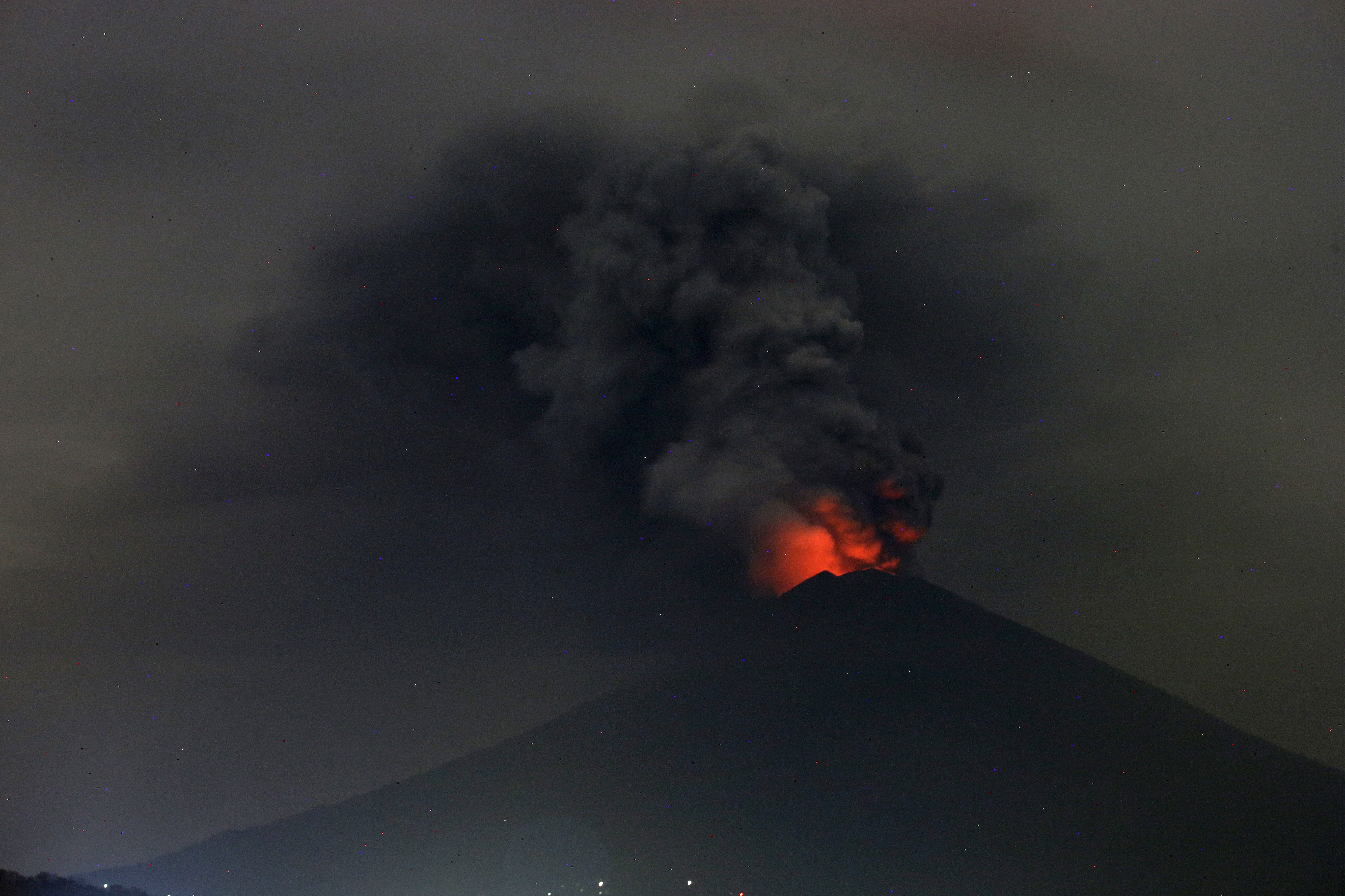 A view of Mount Agung volcano erupting in Karangasem, Bali, Indonesia, Monday, Nov. 27, 2017. Indonesia authorities raised the alert for the rumbling volcano to highest level on Monday and closed the international airport on tourist island of Bali stranding thousands of travelers. (AP Photo/Firdia Lisnawati)