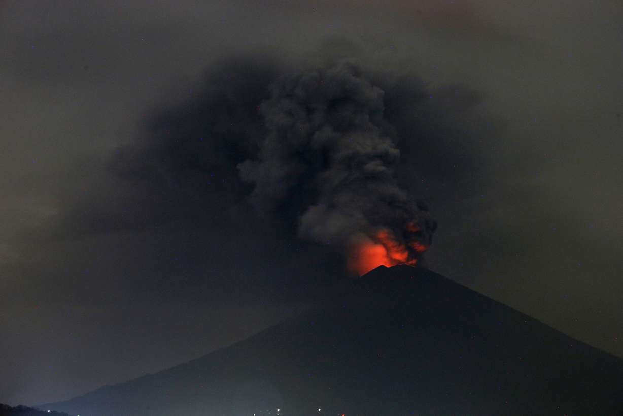 A view of Mount Agung volcano erupting in Karangasem, Bali, Indonesia, Monday, Nov. 27, 2017. Indonesia authorities raised the alert for the rumbling volcano to highest level on Monday and closed the international airport on tourist island of Bali stranding thousands of travelers. (AP Photo/Firdia Lisnawati)