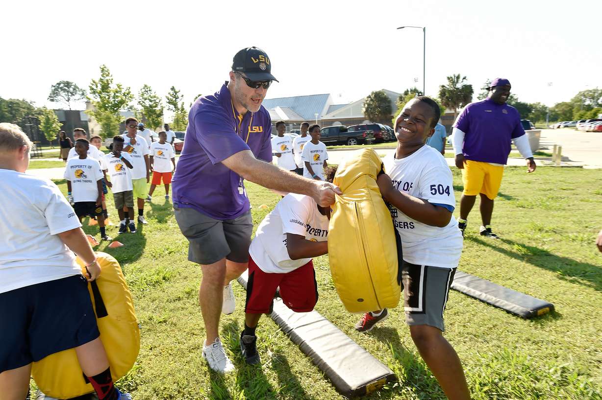 LSU offensive line coach Jeff Grimes works with kids at youth clinic. Thursday morning, BYU announced that it has hired Grimes to become the new offensive coordinator at BYU. (Photo: Steve Franz, LSU Athletics)