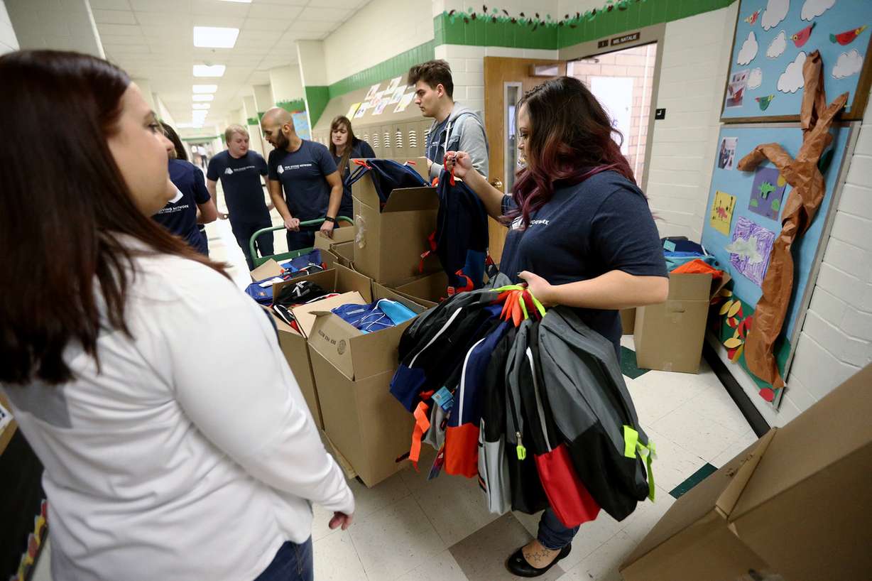 Employees from Primary Residential Mortgage Inc. donate new backpacks and school supplies to all the students at Jackson Elementary School in Salt Lake City on Friday, Dec. 15, 2017. The company gave backpacks and supplies to all the students at Rose Park Elementary School, too. (Photo: Scott G Winterton, KSL)