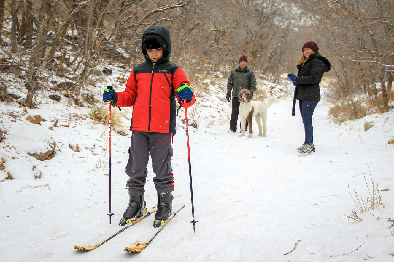 Kousha Farang, who is from Iran and never seen snow before, skis down Neffs Canyon Trail after a fresh dusting of snow in Salt Lake on Saturday, Dec. 16, 2017, as Behrouz Farang and Aazadeh Farang, right, look on. (Photo: Adam Fondren, KSL)