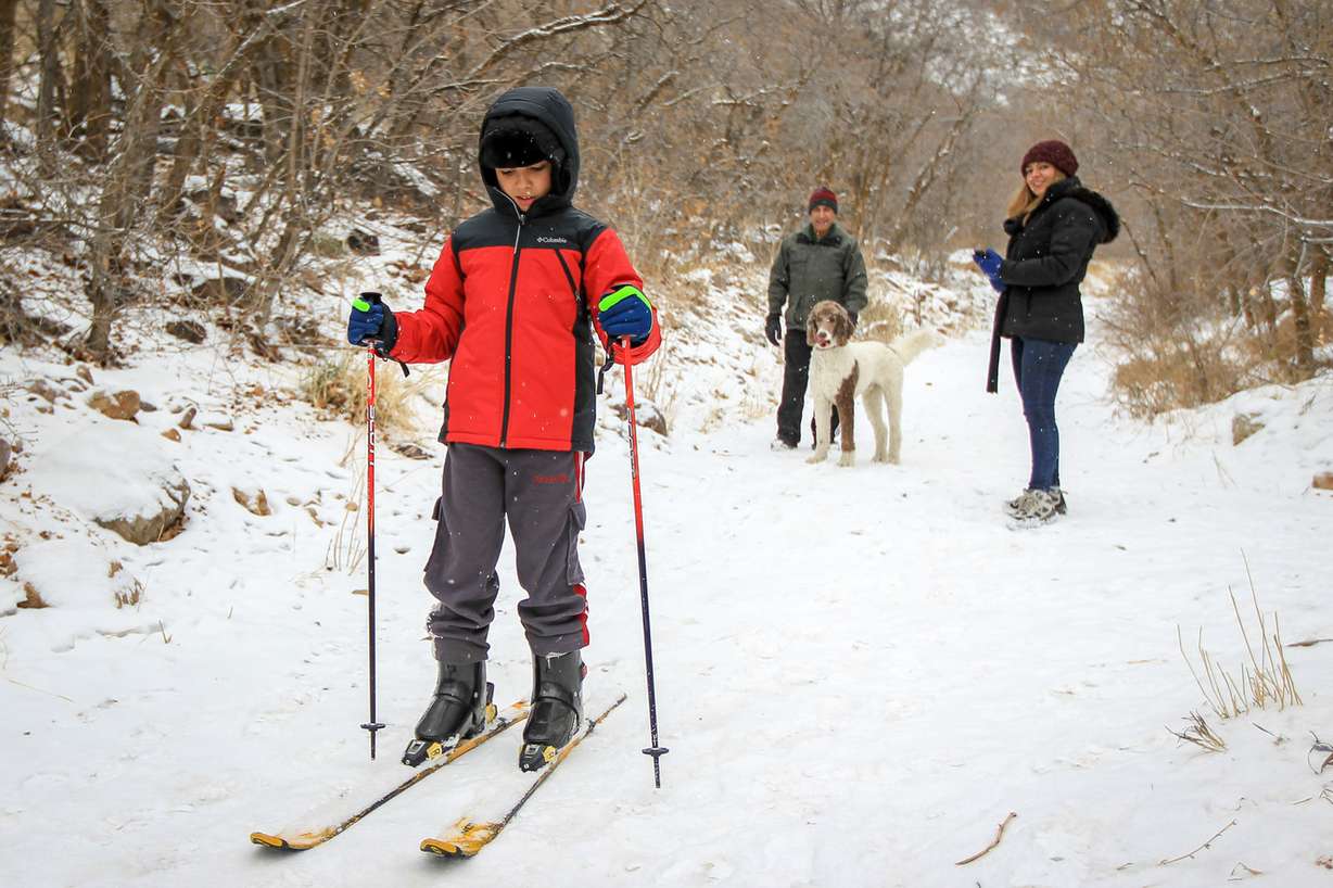 Kousha Farang, who is from Iran and never seen snow before, skis down Neffs Canyon Trail after a fresh dusting of snow in Salt Lake on Saturday, Dec. 16, 2017, as Behrouz Farang and Aazadeh Farang, right, look on. (Photo: Adam Fondren, KSL)