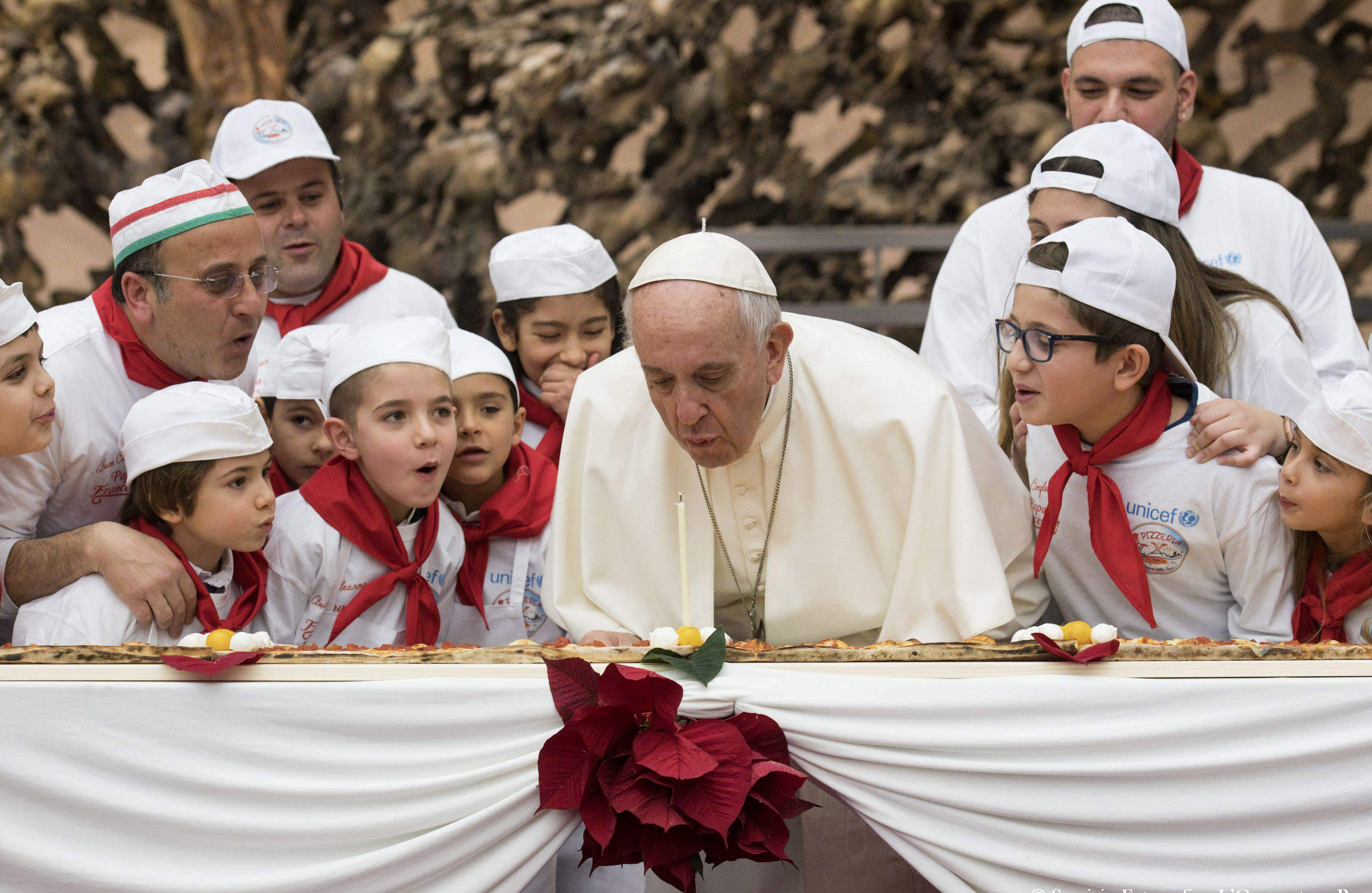 Pope Francis blows out birthday candle on extra-long pizza