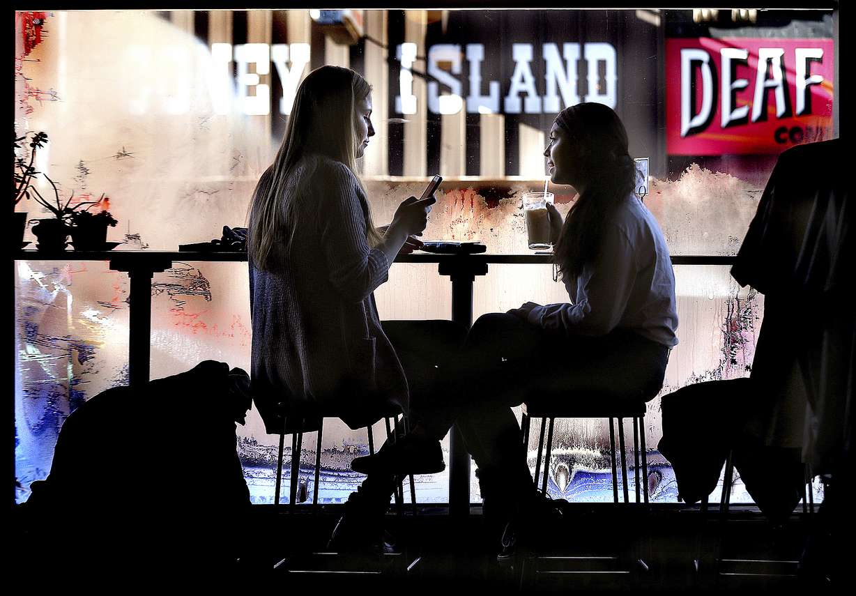 Annie Logan, 16, and Katy Church, 15, visit Tuesday, Dec. 26, 2017, at the Root Note in La Crosse, Wis. where condensation froze to the windows in a sign of the frigid temperatures outside. (Peter Thomson/La Crosse Tribune via AP)