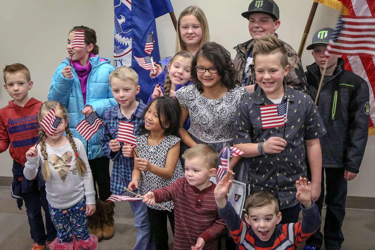 Lachlan Murray, center with glasses, poses for a picture with her adopted family after a citizenship ceremony for children at the U.S Citizenship and Immigration Services' office in Salt Lake City on Thursday, Dec. 28, 2017. Murray is from China. (Photo: Adam Fondren, KSL)