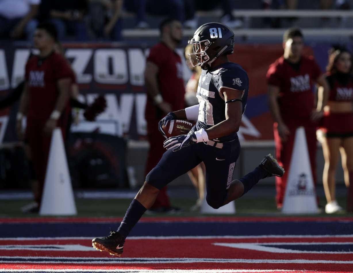 Utah State wide receiver Savon Scarver scores a touchdown on a kickoff against New Mexico State in the first half of the Arizona Bowl NCAA college football game Friday, Dec. 29, 2017, in Tucson, Ariz.