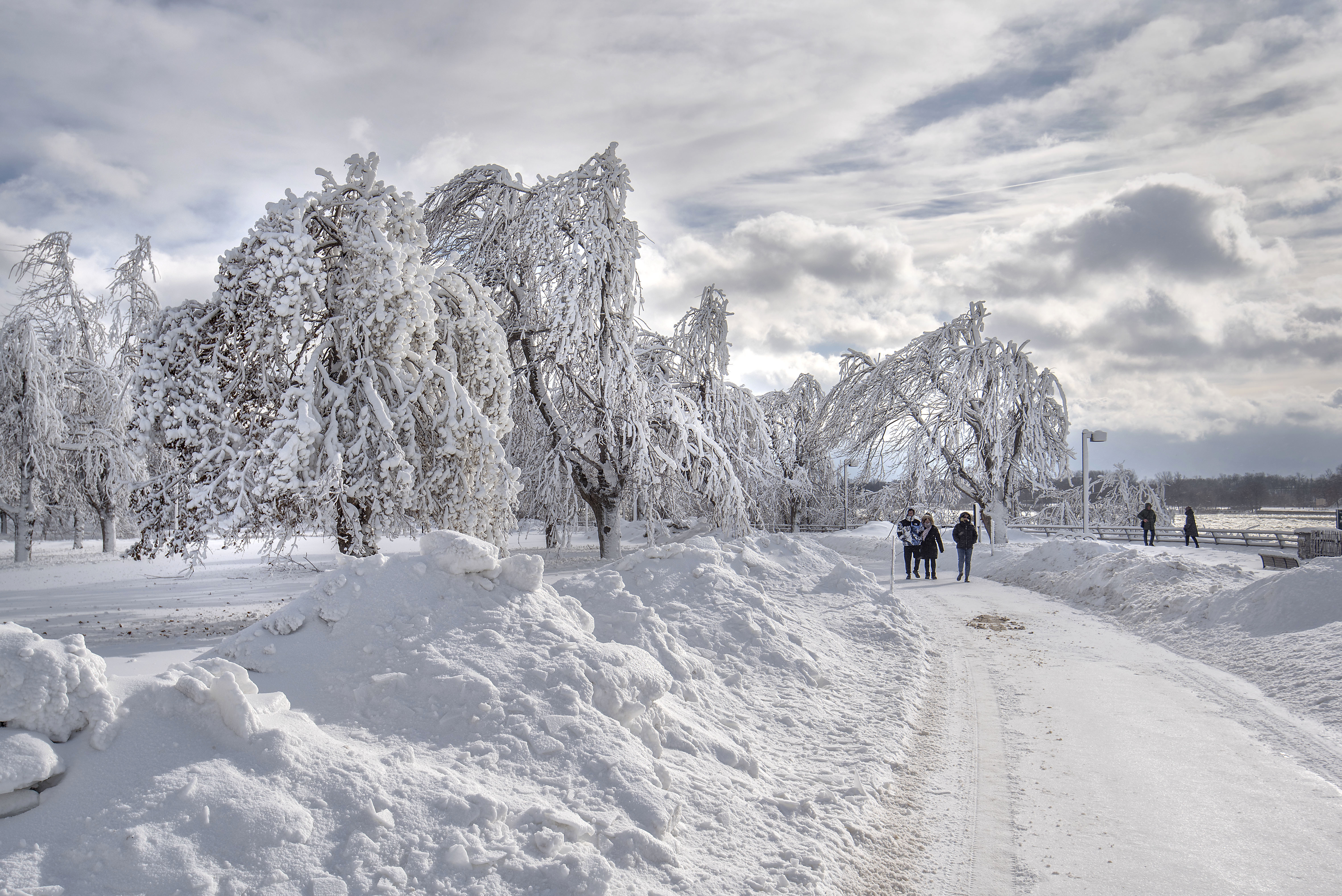 Visitors walk at a frozen Niagara Falls in views from Stedman's Bluff on Goat Island of the American Falls. Visitors to Goat Island at Niagara Falls State Park are treated to a winter wonderland when mist from the falls freeze to the landscape, Tuesday, Jan. 2, 2018. (James Neiss/The Niagara Gazette via AP)