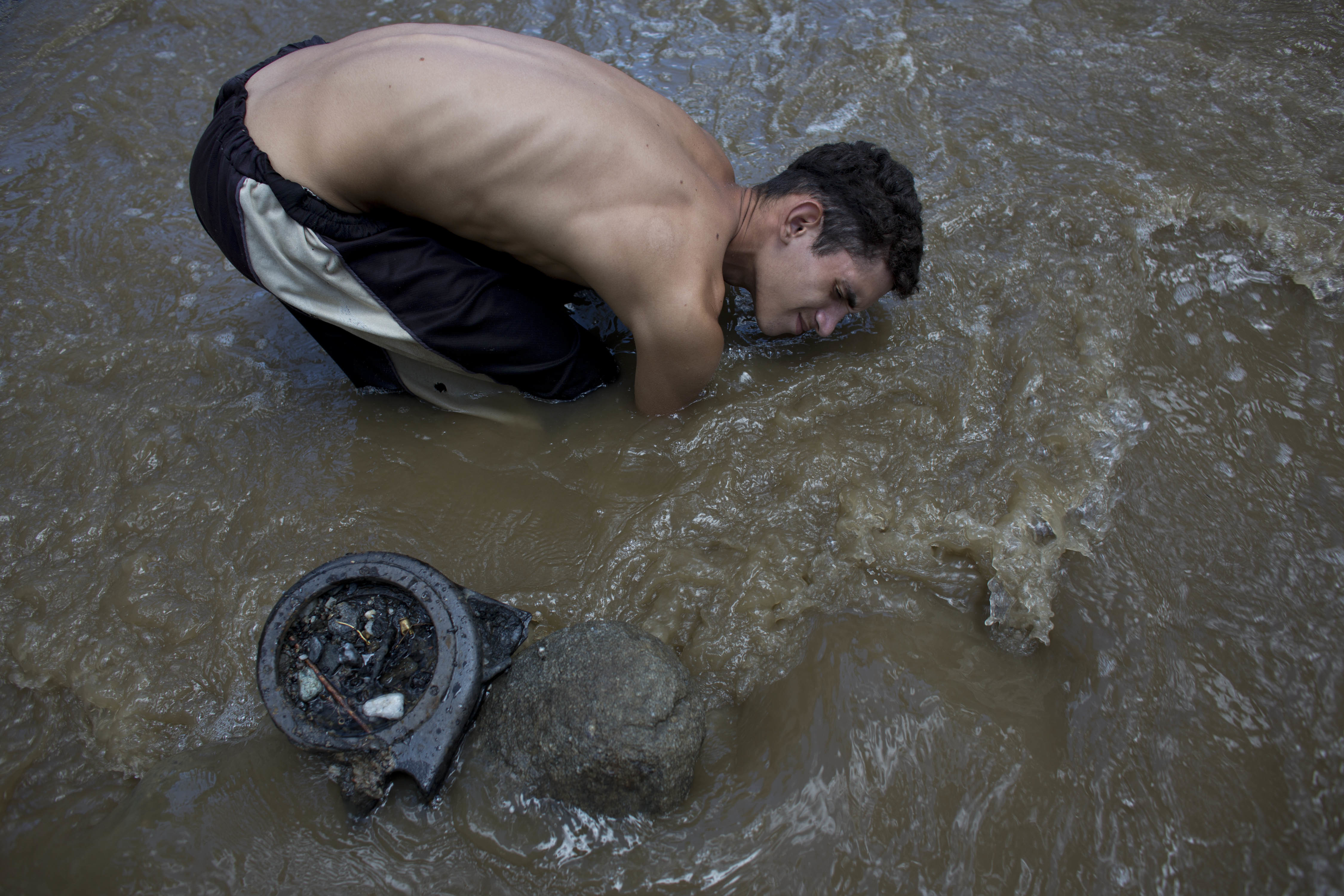 Venezuelans scour polluted river for lost treasure, survival
