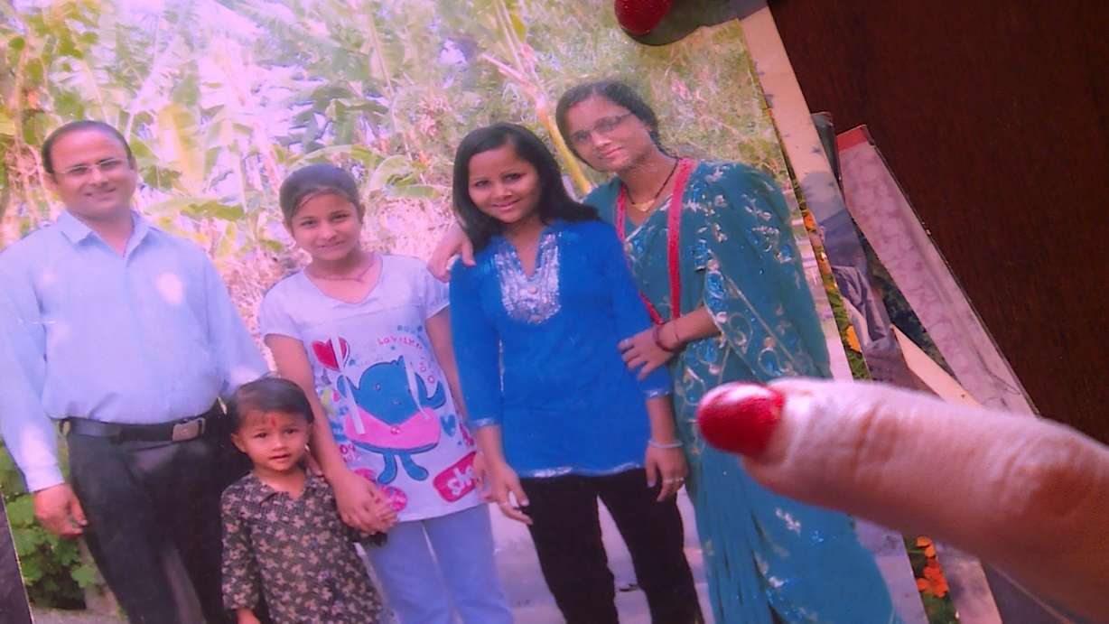 Kiki Sharma points to a picture of her family, taken right before they came to Utah, at the Bhutan House Restaurant in Sandy on Tuesday, Jan. 9, 2018. (Photo: Ray Boone, KSL TV)