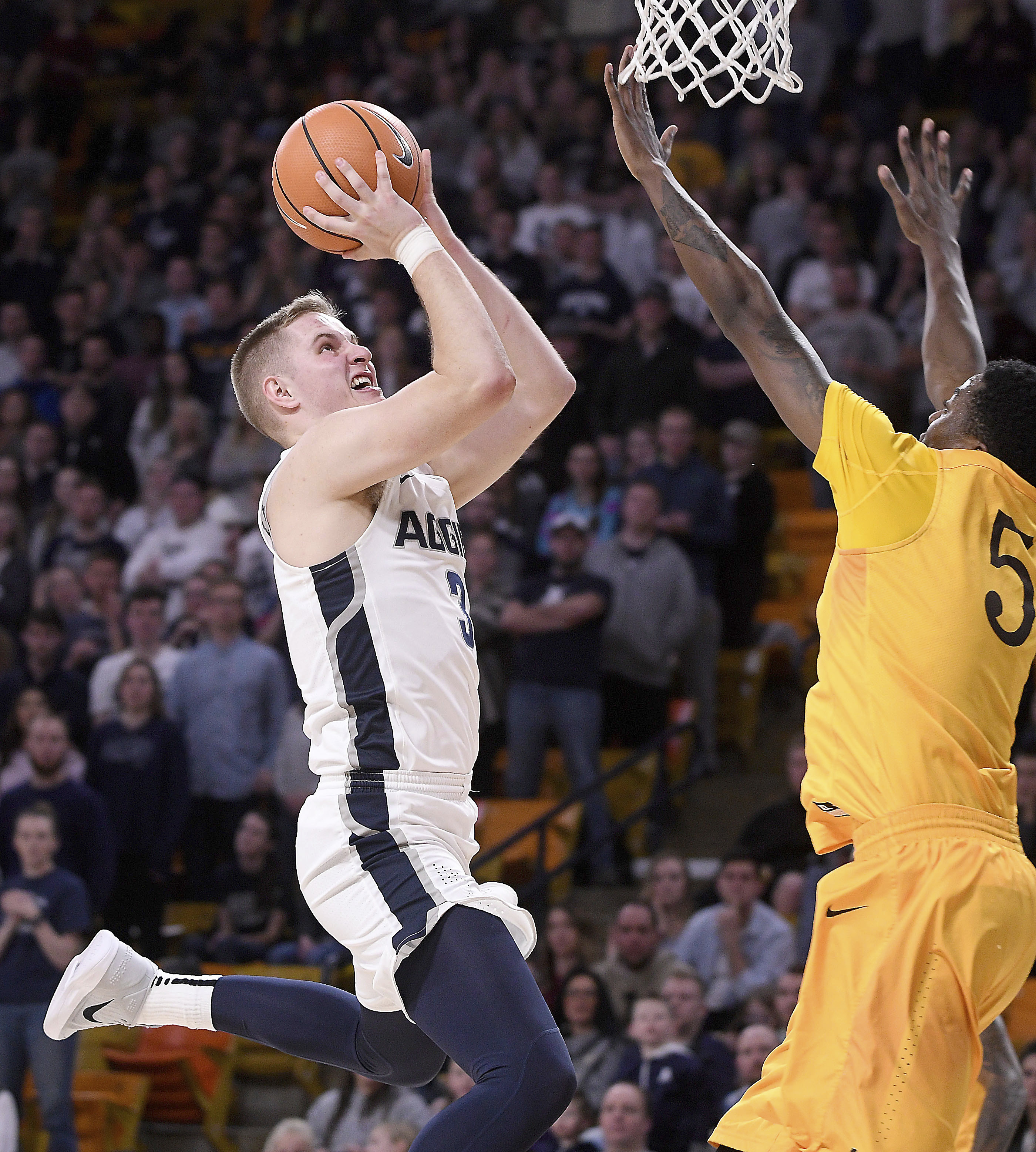 Utah State guard Sam Merrill (3) shoots Wyoming forward Alan Herndon (5) defends during an NCAA college basketball game Saturday, Jan. 20, 2018, in Logan, Utah. (Photo: Eli Lucero, The Herald Journal via AP)