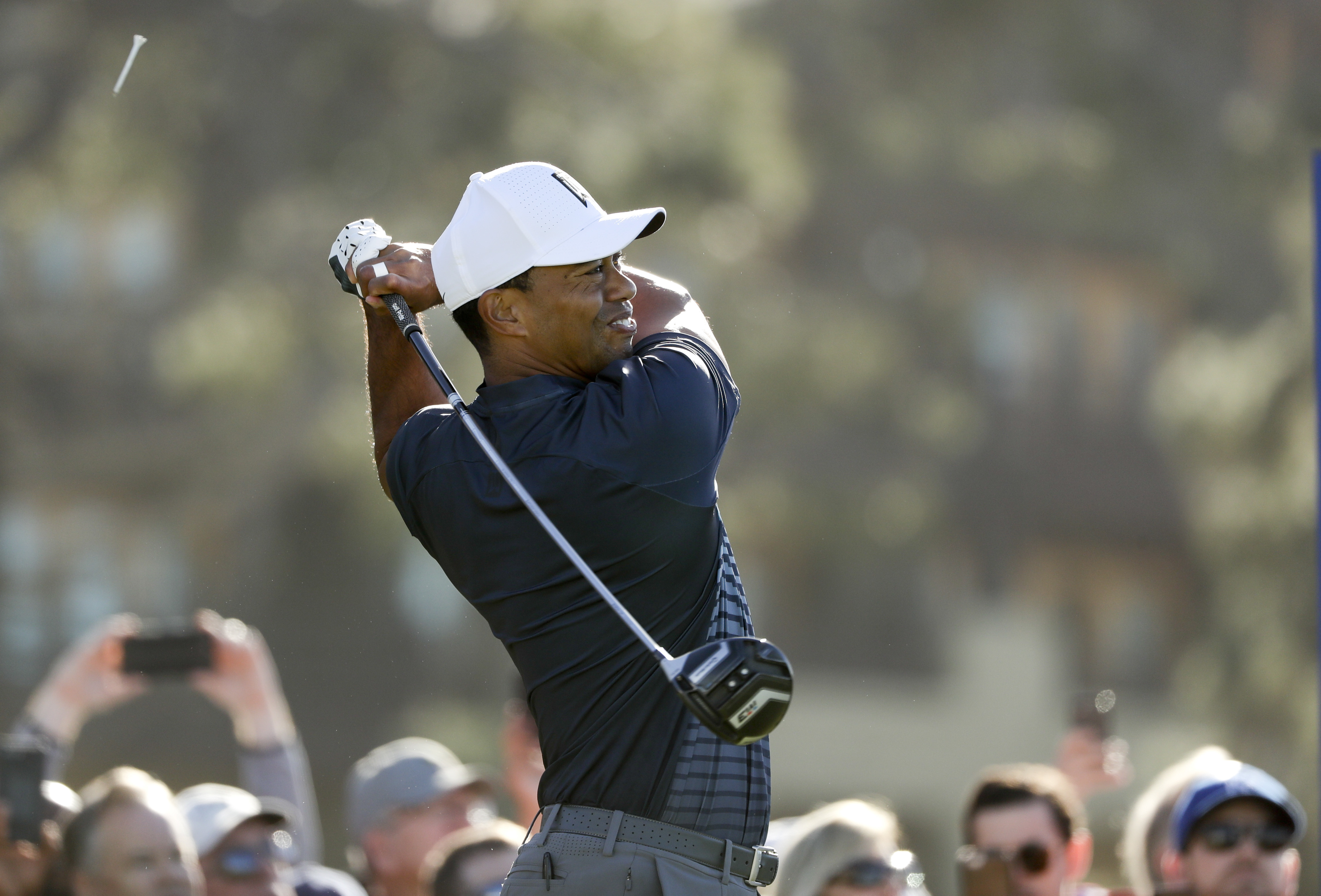 The Latest: A clutch birdie by Woods allows him to make cut