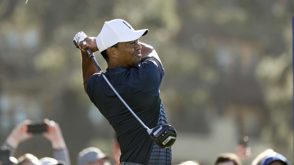 The Latest: A clutch birdie by Woods allows him to make cut