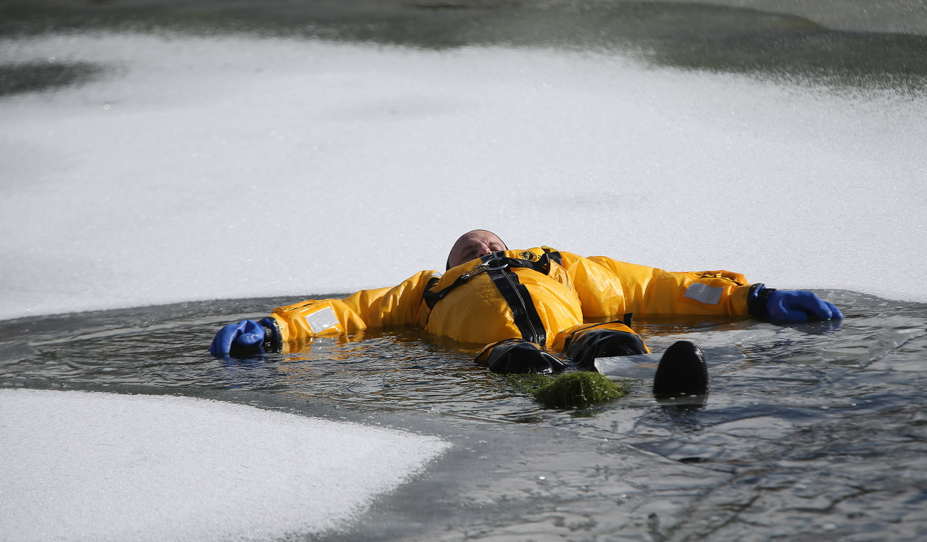 Battalion Chief Ben Bailey waits to be "rescued" as Lone Peak firefighters become certified in ice rescue at the Alpine Country Club in Highland on Friday, Jan. 26, 2018. (Photo: Jeffrey D. Allred, KSL)