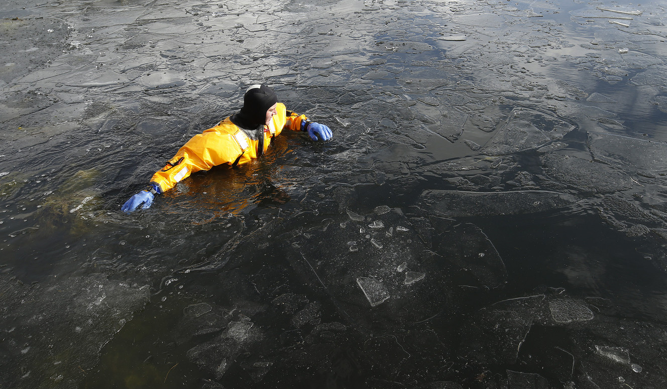 Brandt Godwin wades through the ice water as Lone Peak firefighters become certified in ice rescue at the Alpine Country Club in Highland on Friday, Jan. 26, 2018. (Photo: Jeffrey D. Allred, KSL)