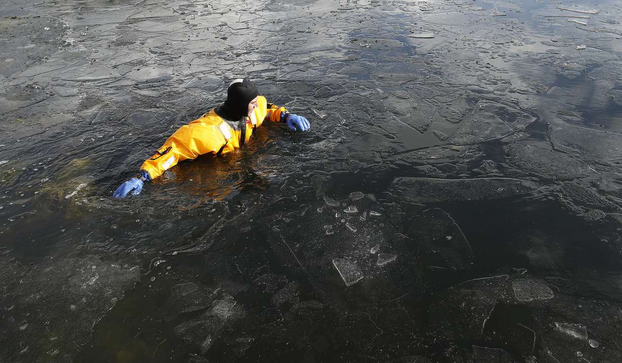 Brandt Godwin wades through the ice water as Lone Peak firefighters become certified in ice rescue at the Alpine Country Club in Highland on Friday, Jan. 26, 2018. (Photo: Jeffrey D. Allred, KSL)