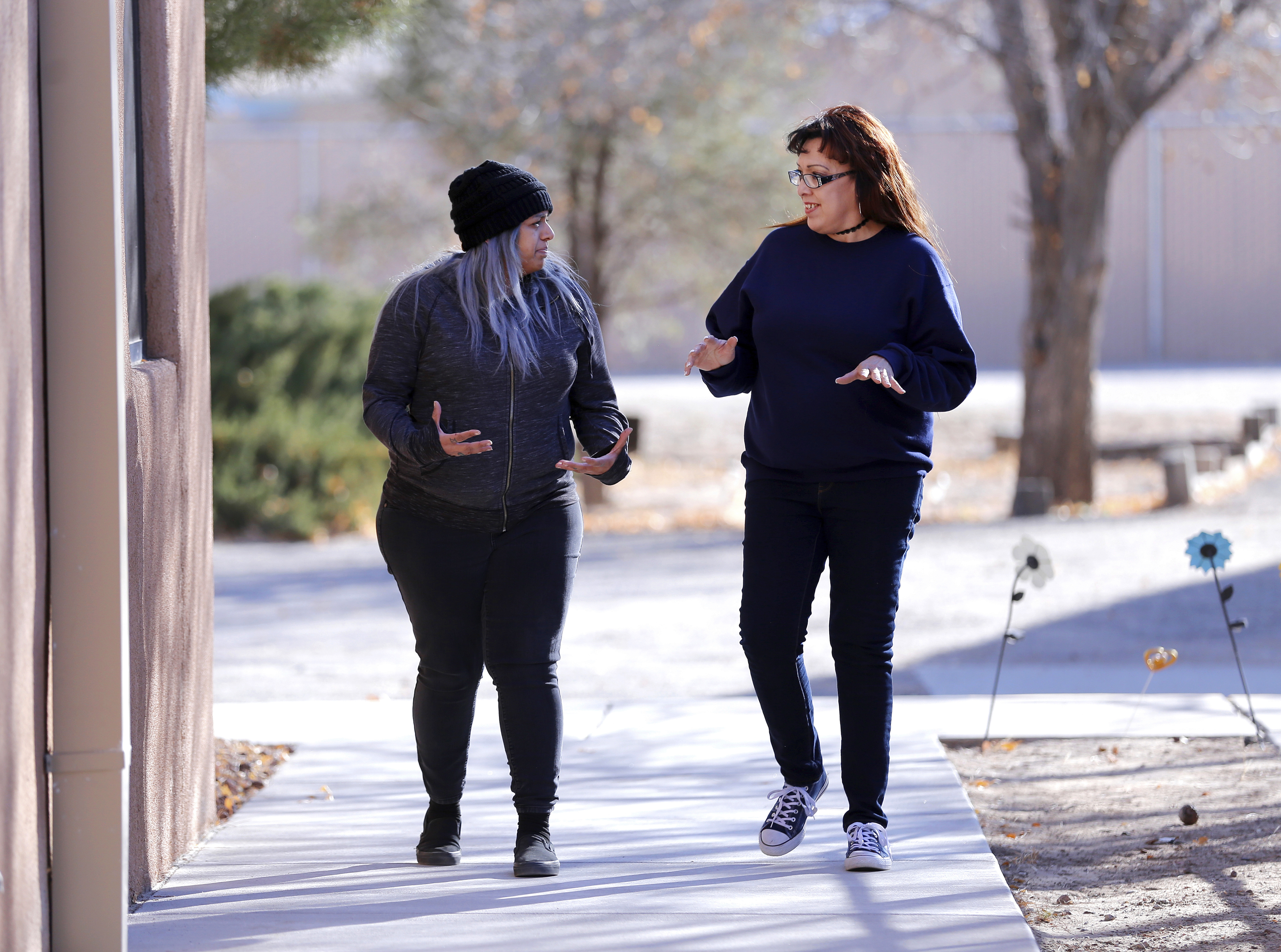 Joleen Valencia, who was held past her scheduled parole date while serving a drug-trafficking sentence, walks with social worker Sheila Ciminera at The Pavilions, a residential re-entry program in Los Lunas, N.M., where she received treatment after her release from prison. New Mexico prison records show the state has held hundreds of inmates, like Valencia, past their projected parole dates under a practice widely known as “in-house parole.” (Eric Draper, AP)