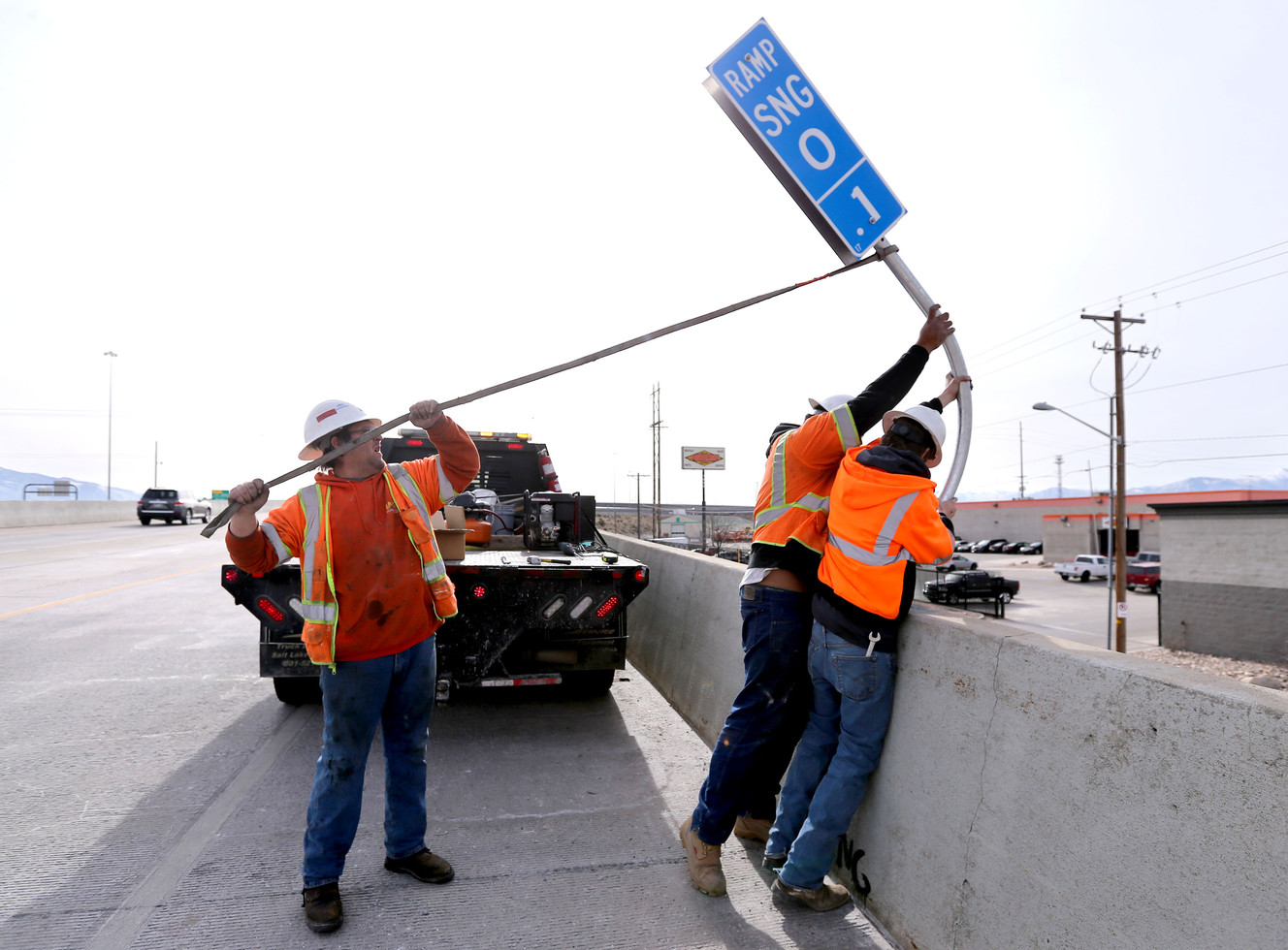 Derek Noorda, Joahaz Fitu and Dustin Henstrom install new mile marker signs to help identify locations on highway ramps and interchanges in Salt Lake City on Wednesday, Jan. 31, 2018. (Photo: Kristin Murphy, KSL)