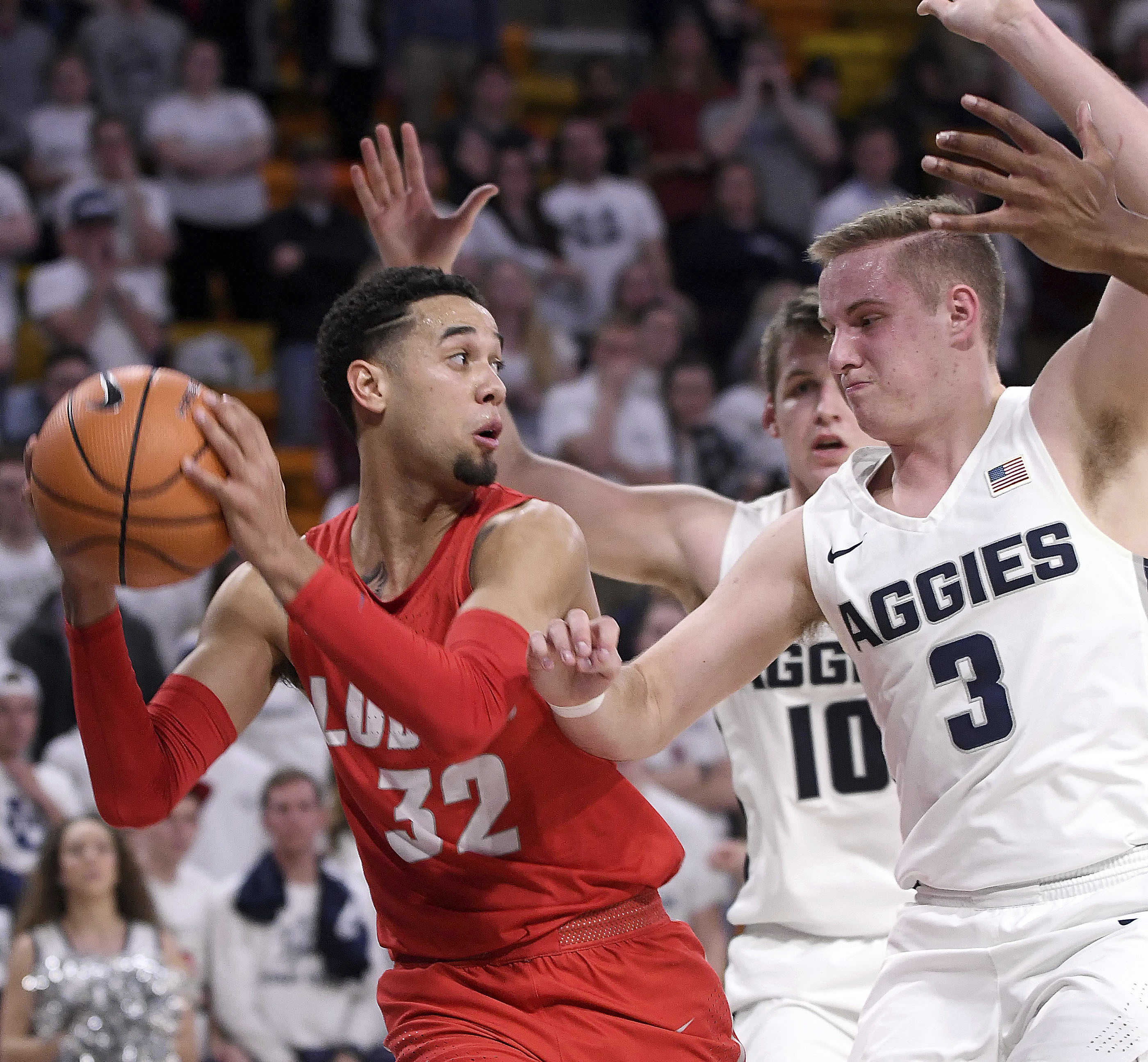 New Mexico guard Anthony Mathis (32) looks to pass the ball as Utah State guard Sam Merrill (3) and forward Quinn Taylor (10) defend during an NCAA college basketball game Wednesday, Jan. 31, 2018, in Logan, Utah. (Eli Lucero, The Herald Journal via AP)