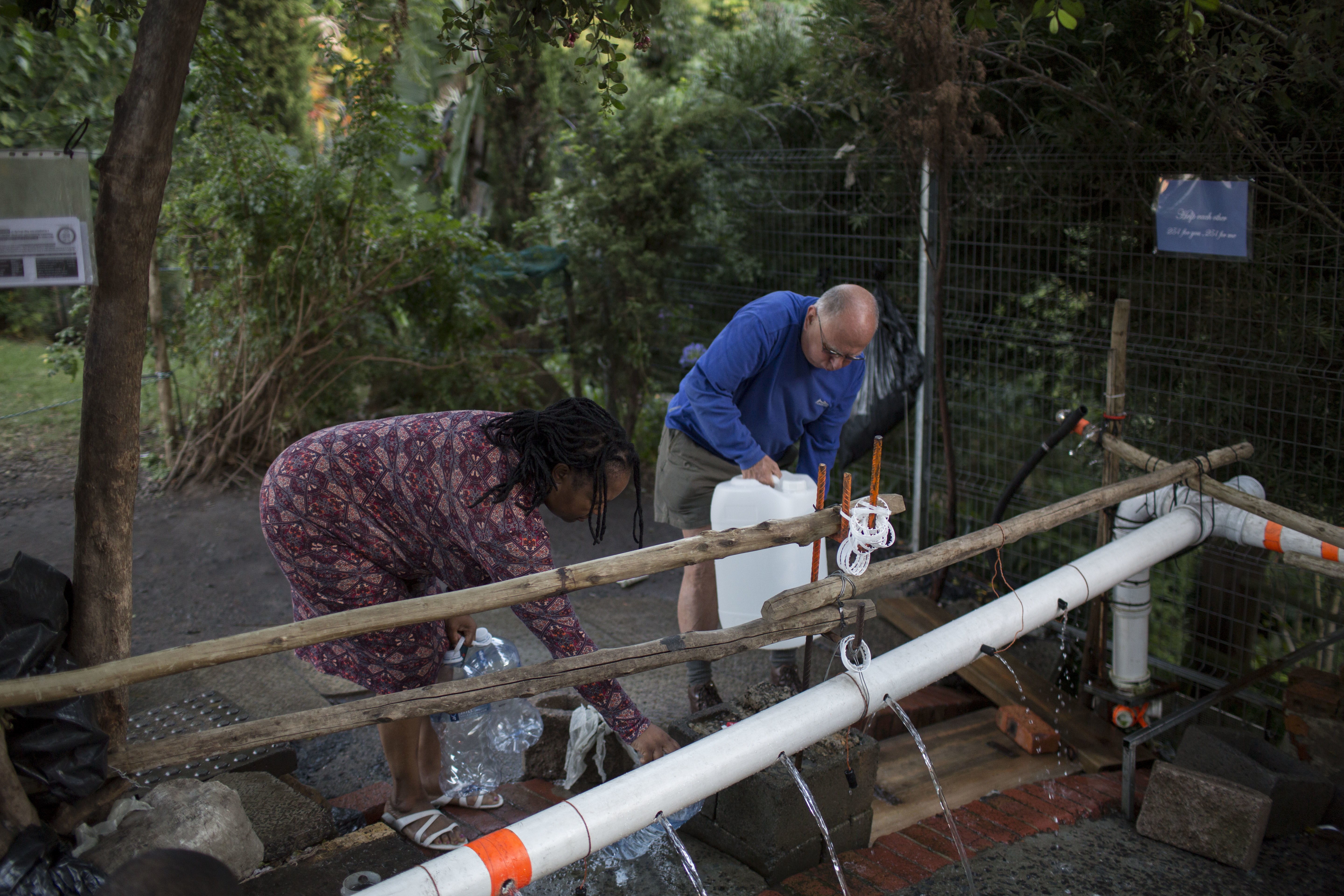 People collect water from a source of natural spring water in Cape Town, Thursday, Feb. 1, 2018. South Africa's drought-hit city of Cape Town plans to introduce new water restrictions on Thursday in an attempt to avoid what it calls "Day Zero," the day in mid-April when it might have to turn off most taps. (Bram Janssen, AP Photo)