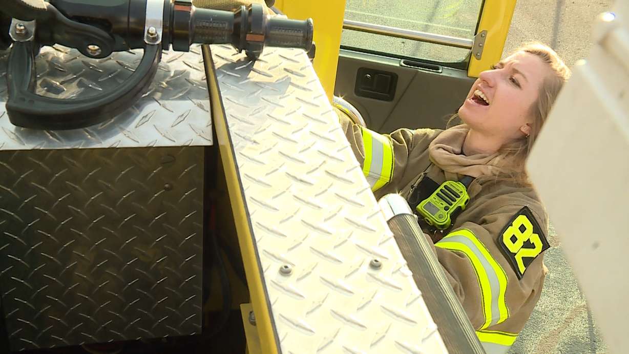 Firefighter Aubrey Freiberg calls for "more slack" as she places a hose back in its place on the side of the crew's fire truck on January 30, 2018. (Photo: Ray Boone, KSL TV)