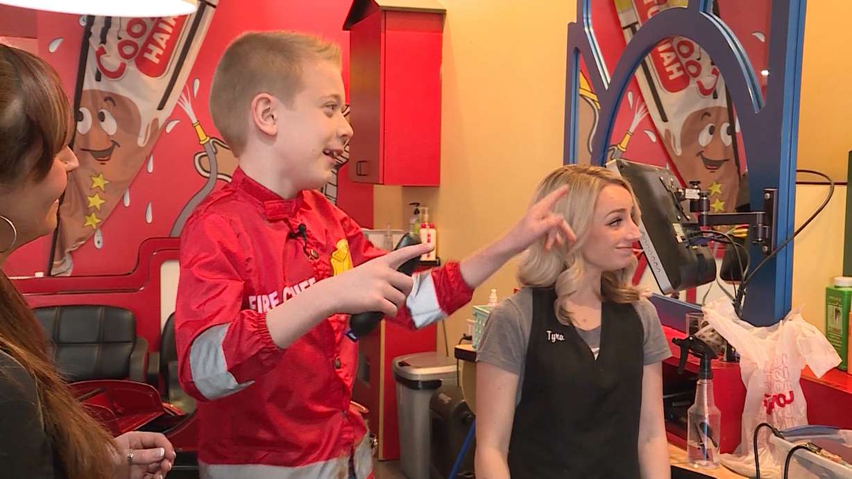 After growing his hair out for over two years, 8-year-old Tate Morgan (center) cut his locks on Feb. 16, 2018, so his hair could benefit children with cancer. (KSL TV)