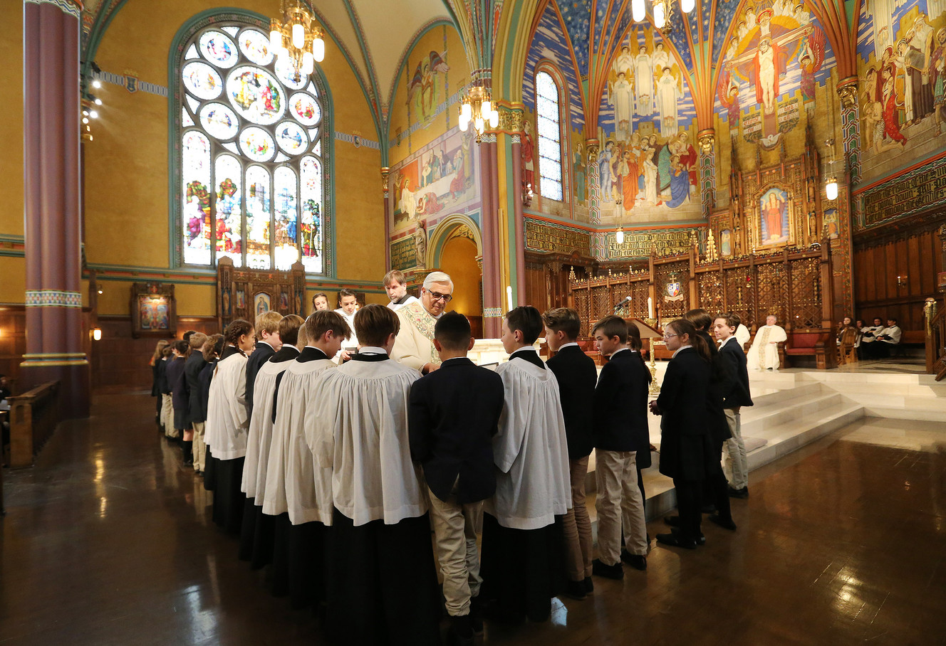Monsignor Joseph M. Mayo hands out Nicene Creeds to sixth-grade students of the Madeleine Choir School during Mass at the Cathedral of the Madeleine in Salt Lake City on Wednesday, Feb. 21, 2018. Wednesday marked the 25th anniversary of the cathedral’s rededication, and following the Mass, students and faculty of the Madeleine Choir School presented Monsignor M. Francis Mannion with the Legacy of Service Award, acknowledging his efforts and years of work that have transformed the cathedral and its ministries. (Photo: Jeffrey D. Allred, KSL)