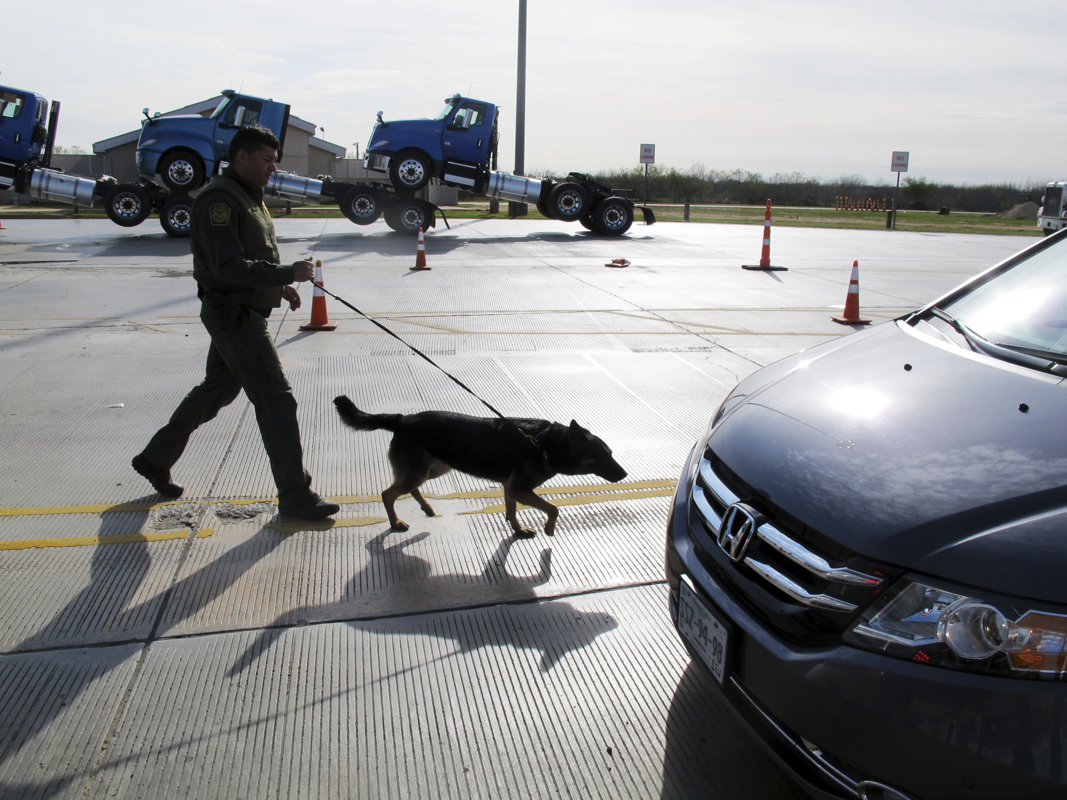 A Border Patrol agent uses a dog to inspect vehicles lining up at the Laredo North vehicle checkpoint in Laredo, Texas, on Friday, Feb. 2, 2018. The Border Patrol estimates that about 9,000 vehicles pass through their checkpoint every day, many coming north from Mexico. (Photo: Nomaan Merchant, AP)