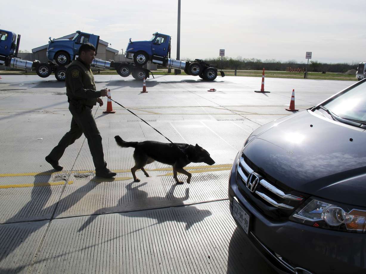 A Border Patrol agent uses a dog to inspect vehicles lining up at the Laredo North vehicle checkpoint in Laredo, Texas, on Friday, Feb. 2, 2018. The Border Patrol estimates that about 9,000 vehicles pass through their checkpoint every day, many coming north from Mexico. (Photo: Nomaan Merchant, AP)