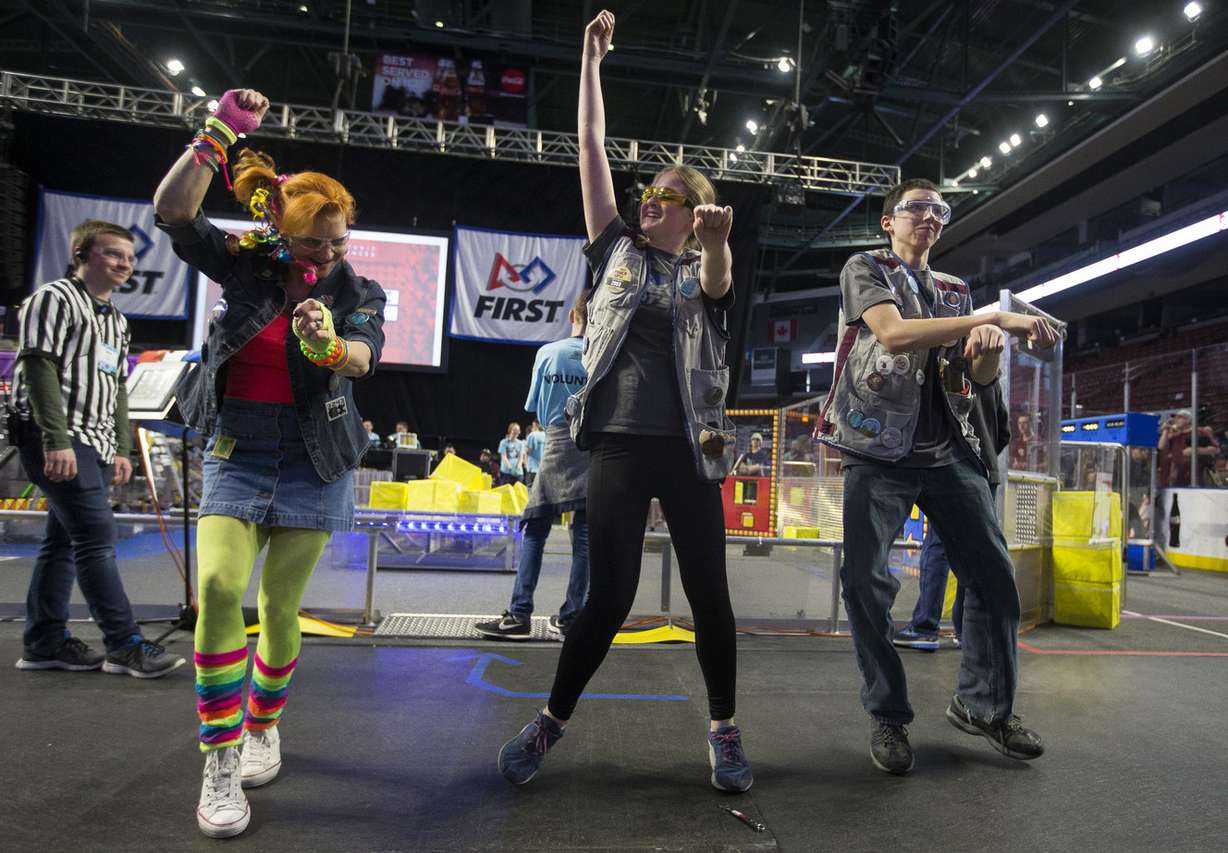 Jeanine Rueb, master of ceremonies for the FIRST Robotics Competition, dances with Taycee Newman and Jayse Hall, both sophomores at InTech Collegiate High School, during a pause in the competition at the Maverik Center in West Valley City on Saturday, March 3, 2018. More than 70 schools took part in the Friday and Saturday competition. (Photo: Jacob Wiegand, KSL)