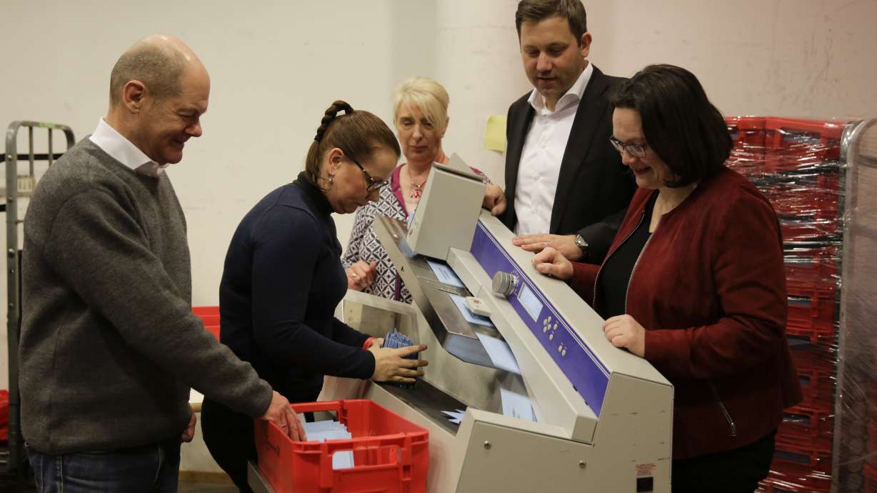 The Latest: France's Macron happy with Merkel back in charge