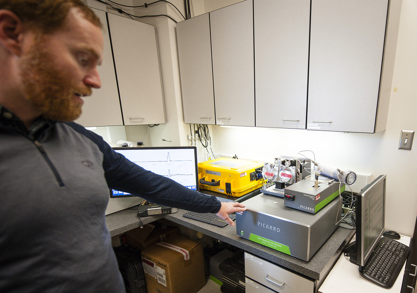 Logan Mitchell, a postdoctoral scholar, explains how a laser is used to measure greenhouse gasses in the greenhouse gas analyzer at the Utah Atmospheric Trace Gas and Air Quality lab in the Browning Building at the University of Utah in Salt Lake City on Monday, March 12, 2018. (Photo: Adam Fondren, KSL)