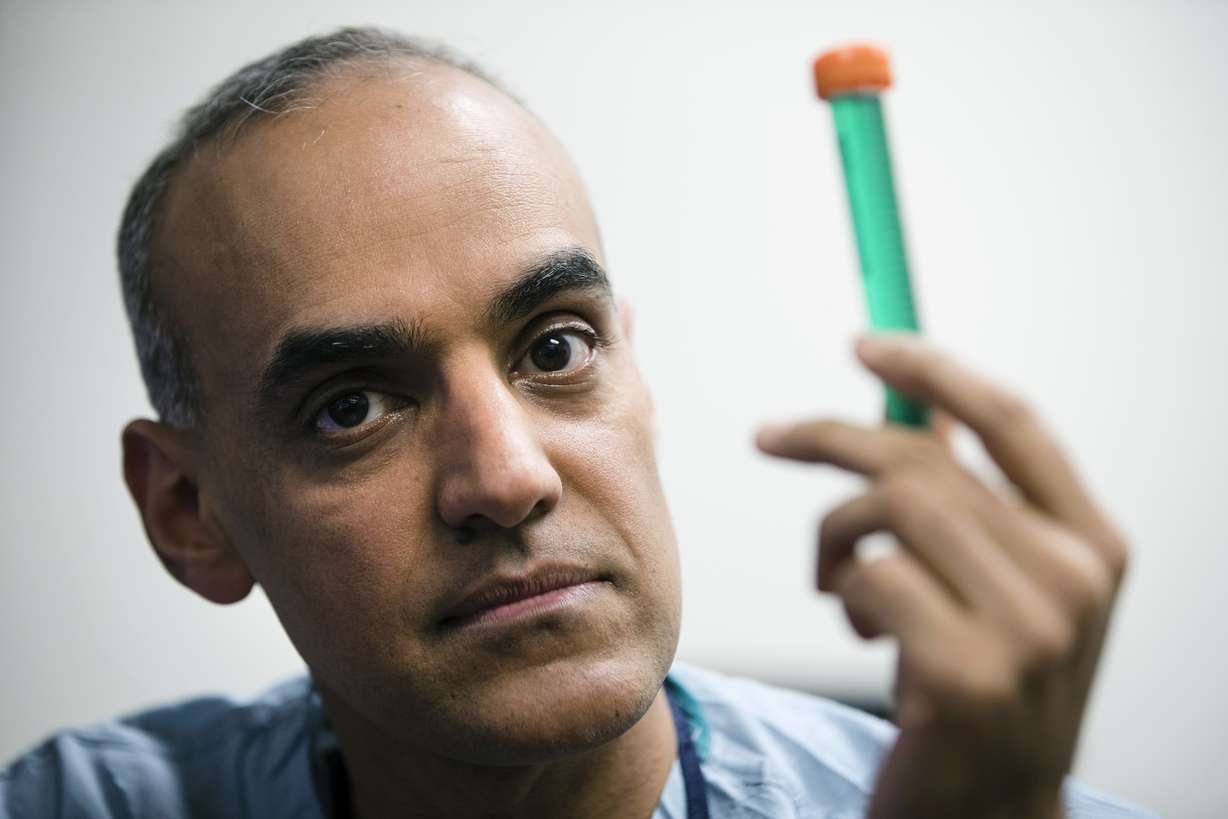 Surgeon Dr. Sunil Singhal poses for a photograph with a vial of fluorescent dye at the Hospital of the University of Pennsylvania in Philadelphia, Tuesday, Jan. 23, 2018. Photo: Matt Rourke, AP Photo