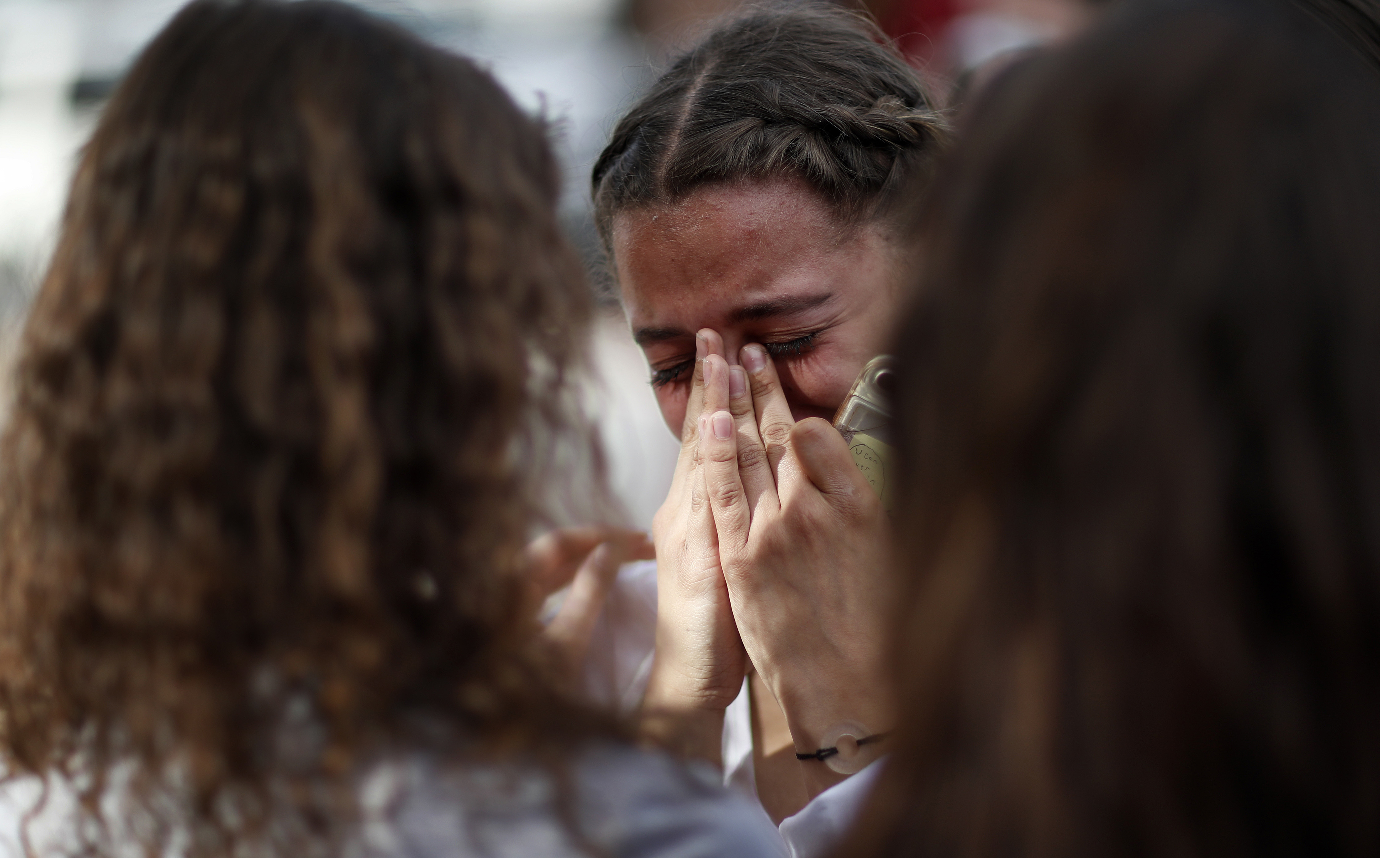 A student cries during a walk out at the Las Vegas Academy of the Arts, Wednesday, March 14, 2018, in Las Vegas. Students at several Nevada high schools walked out of classes to mark the one-month anniversary of a shooting at a campus in Florida and to call for lawmakers to act to curb gun violence. (AP Photo/John Locher)