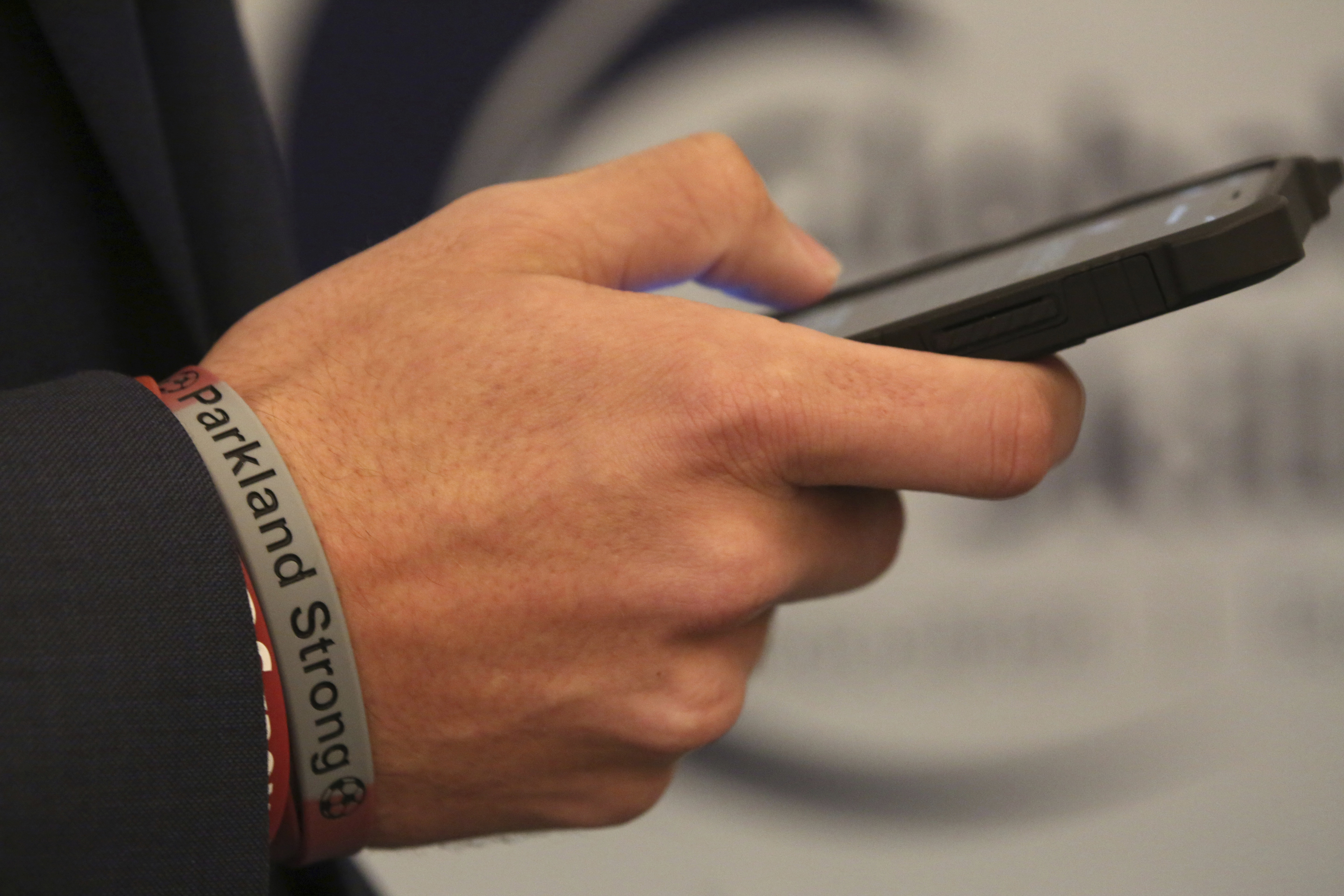 A Parkland High School bracelet is seen on the wrist of student Lewis Mizen in Dubai, United Arab Emirates, Saturday, March 17, 2018. Student survivors of a Florida high school shooting took their message calling for greater gun safety measures abroad for the first time on Saturday, sharing with educational professionals from around the world their frightening experience. (AP Photo/Jon Gambrell)