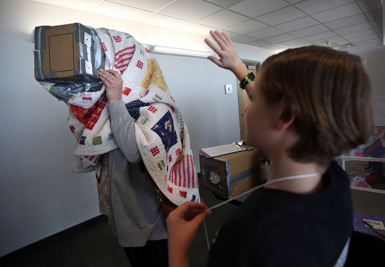 Kepler Smith, right, waves to judge April Oaks as she looks through Smith's Camera Obscura at the University of Utah Science and Engineering Fair. Photo: Kristin Murphy, KSL