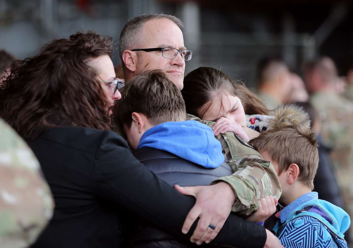 Sgt. 1st class Michael Mills' family gathers hugs him during a deployment ceremony at Roland R. Wright Air Base in Salt Lake City on Monday, March 26, 2018. The Utah Army National Guard's 65th Field Artillery Brigade is deploying to the Middle East in support of Operation Spartan Shield. (Photo: Scott G Winterton, KSL)