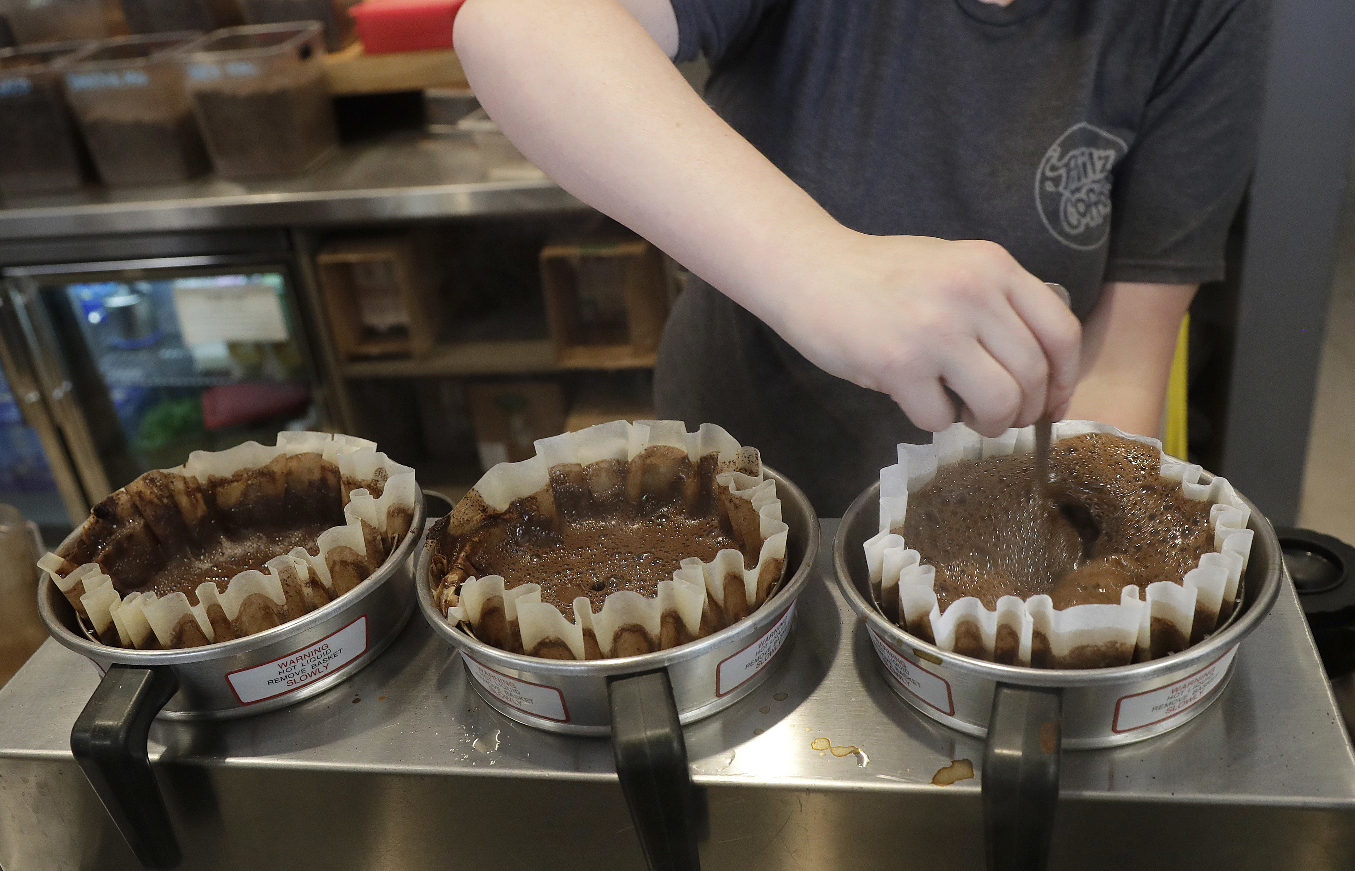 Ashlee Jones prepares coffee at a Philz Coffee shop in San Francisco, Friday, March 30, 2018. Coffee sellers will have to post ominous warnings in California because each cup contains a chemical linked to cancer, a judge ruled. (AP Photo/Jeff Chiu)
