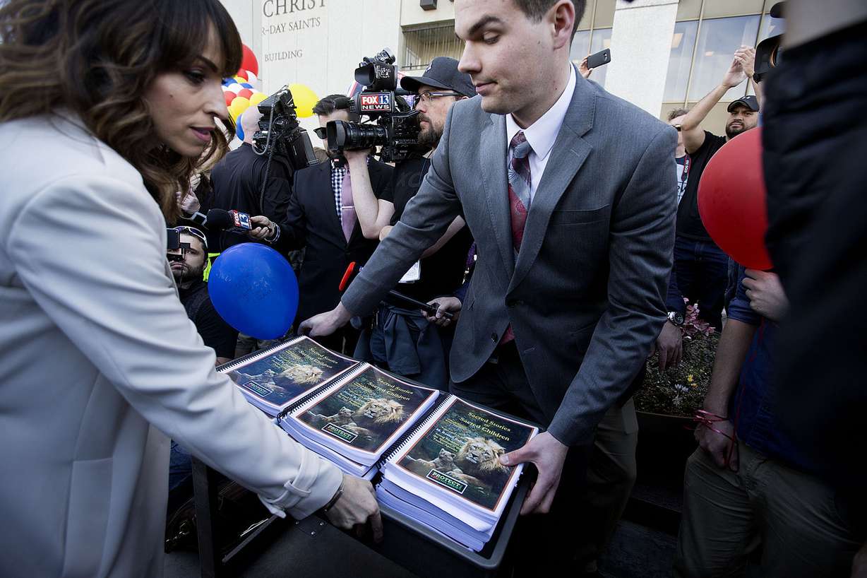 Robin Day, left, hands Irene Caso, of LDS Church Public Affairs, right, a copy of what the group Protect LDS Children say are more 400 stories of those affected by abuse at the hands of church officials during a protest in Salt Lake City on Friday, March 30, 2018. Attendees at the event called for further changes to church policies regarding local bishops' interviews of minors. (Photo: Laura Seitz, KSL)
