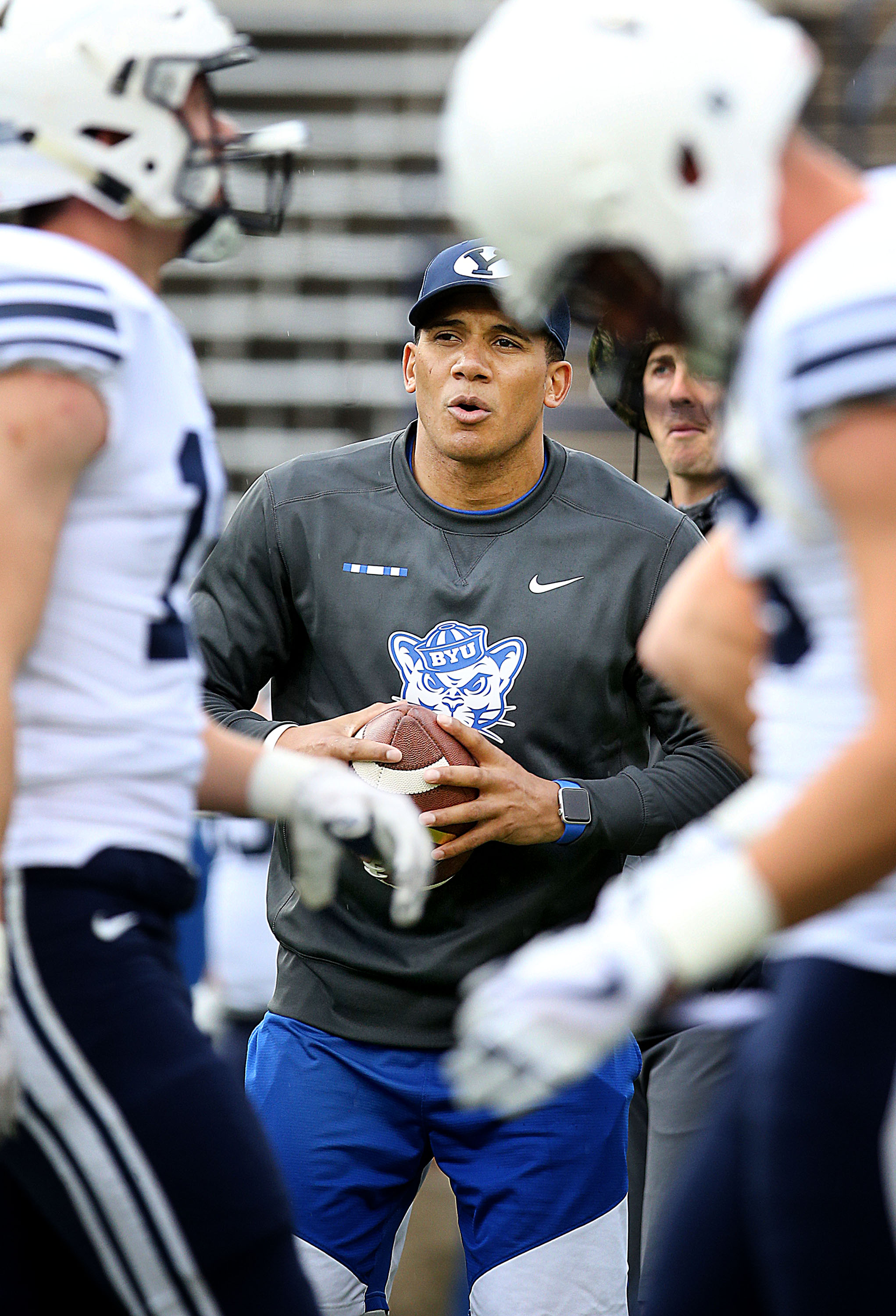 Safeties coach Preston Hadley throws to his players while warming up before the Blue-White game at LaVell Edwards Stadium in Provo on Saturday, April 7, 2018.