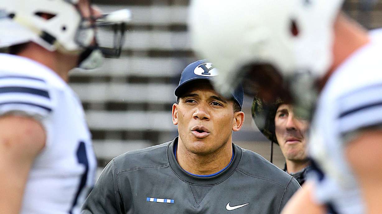 Safeties coach Preston Hadley throws to his players while warming up before the Blue-White game at LaVell Edwards Stadium in Provo on Saturday, April 7, 2018.