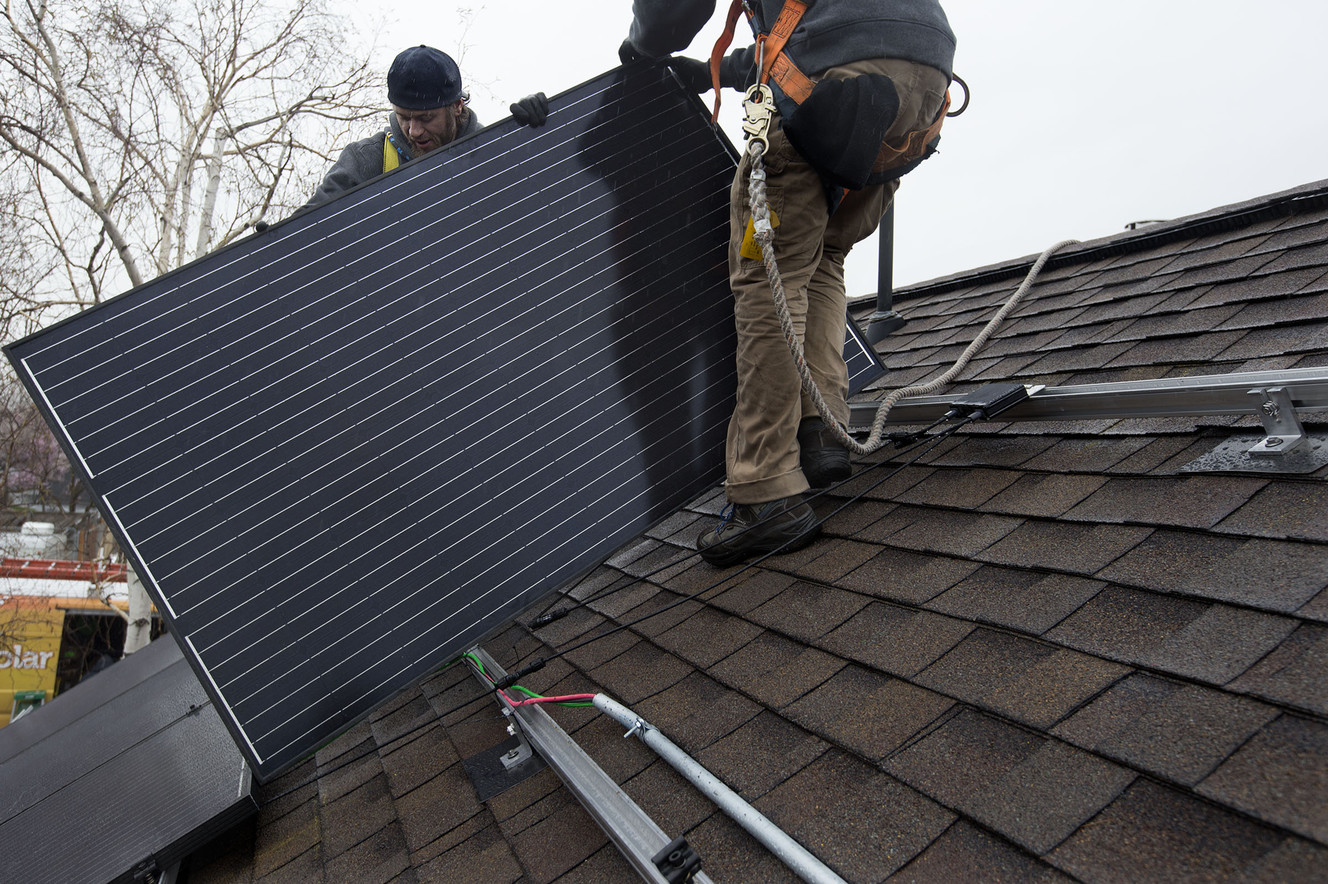 Justin Kourbelas, left, and Tyler Eichmeier, of Go Solar Energy, install solar panels on a house in Holladay on Friday, April 6, 2018. (Photo: Laura Seitz, KSL)