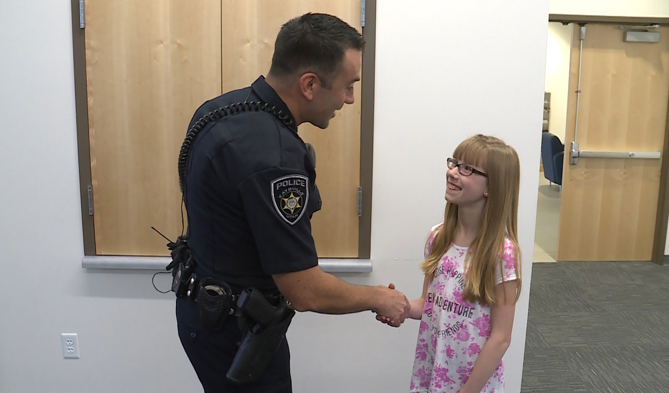 Kaysville police detective Michael Martinez shakes the hand of sixth-grader Amara Dibb in Kaysville on Tuesday, April 10, 2018. (Photo: John Wilson, KSL)