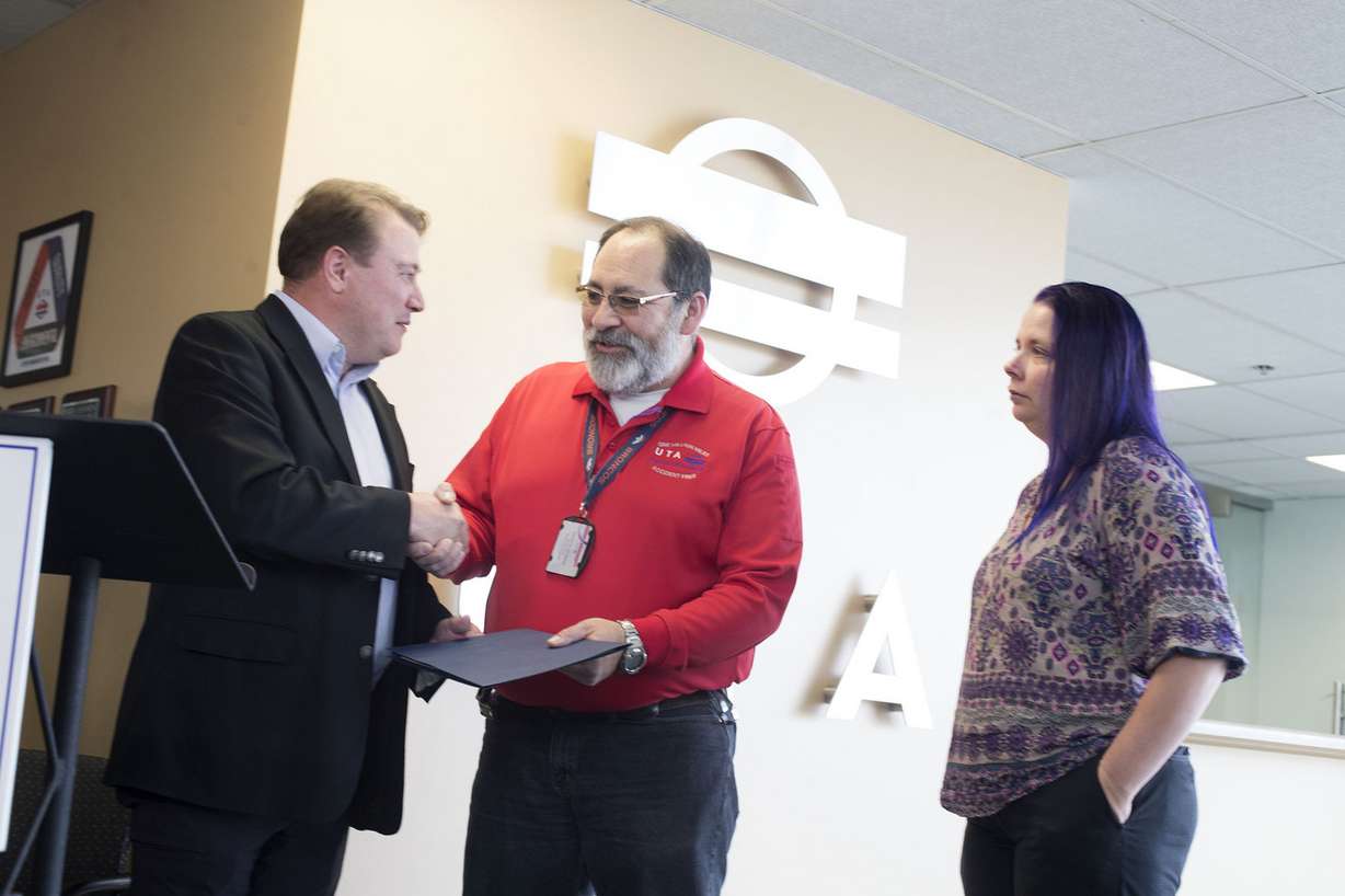Bruce Cardon, Utah Transit Authority's commuter rail general manager, hands FrontRunner operator Francis Rendon a certificate of excellence as Ashley Kofford watches at the UTA headquarters in Salt Lake City on Wednesday, April 11, 2018. Kofford credits Rendon for saving her son's life. (Photo: Laura Seitz, KSL)