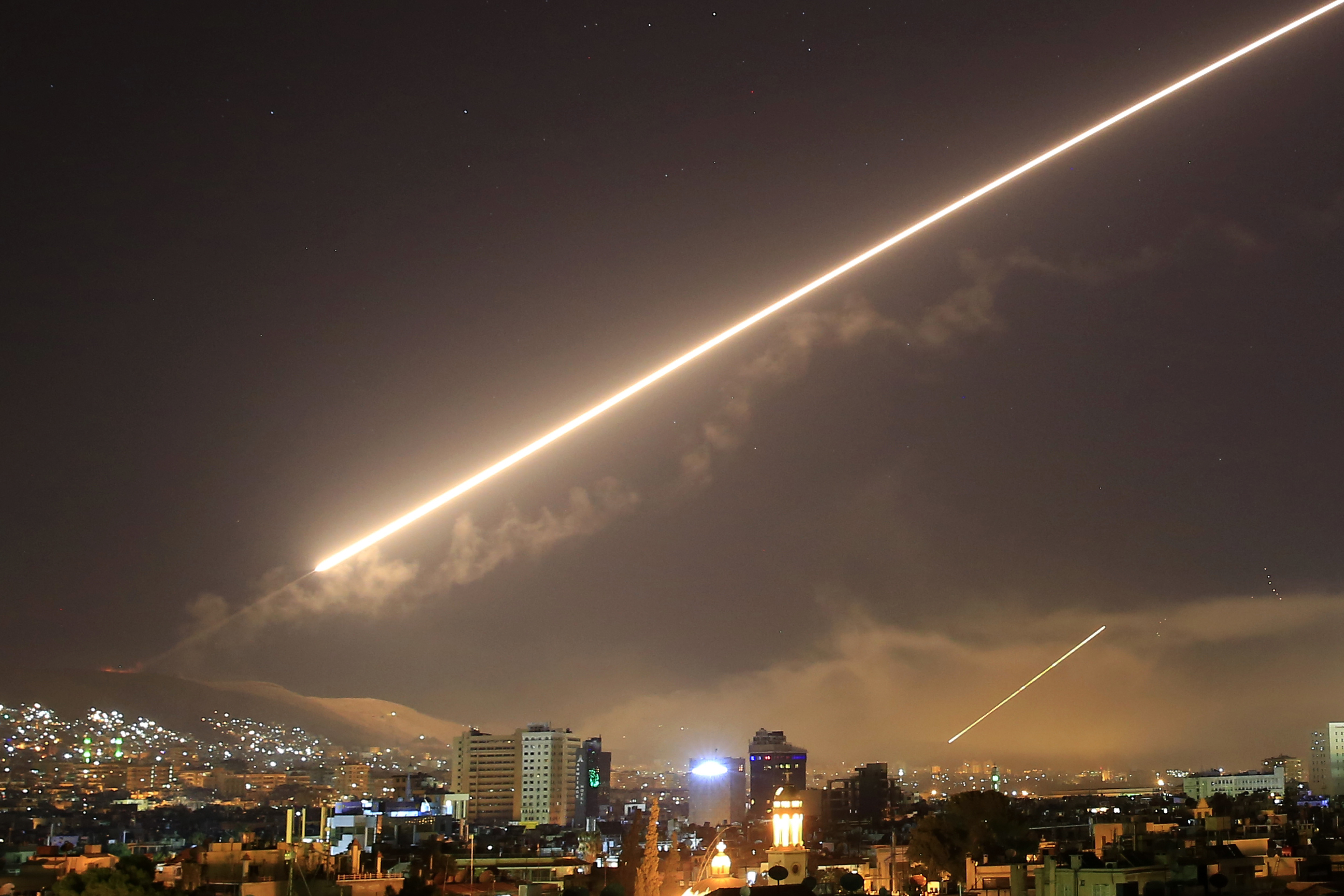 Before dawn, the streak of a missile across Damascus' sky