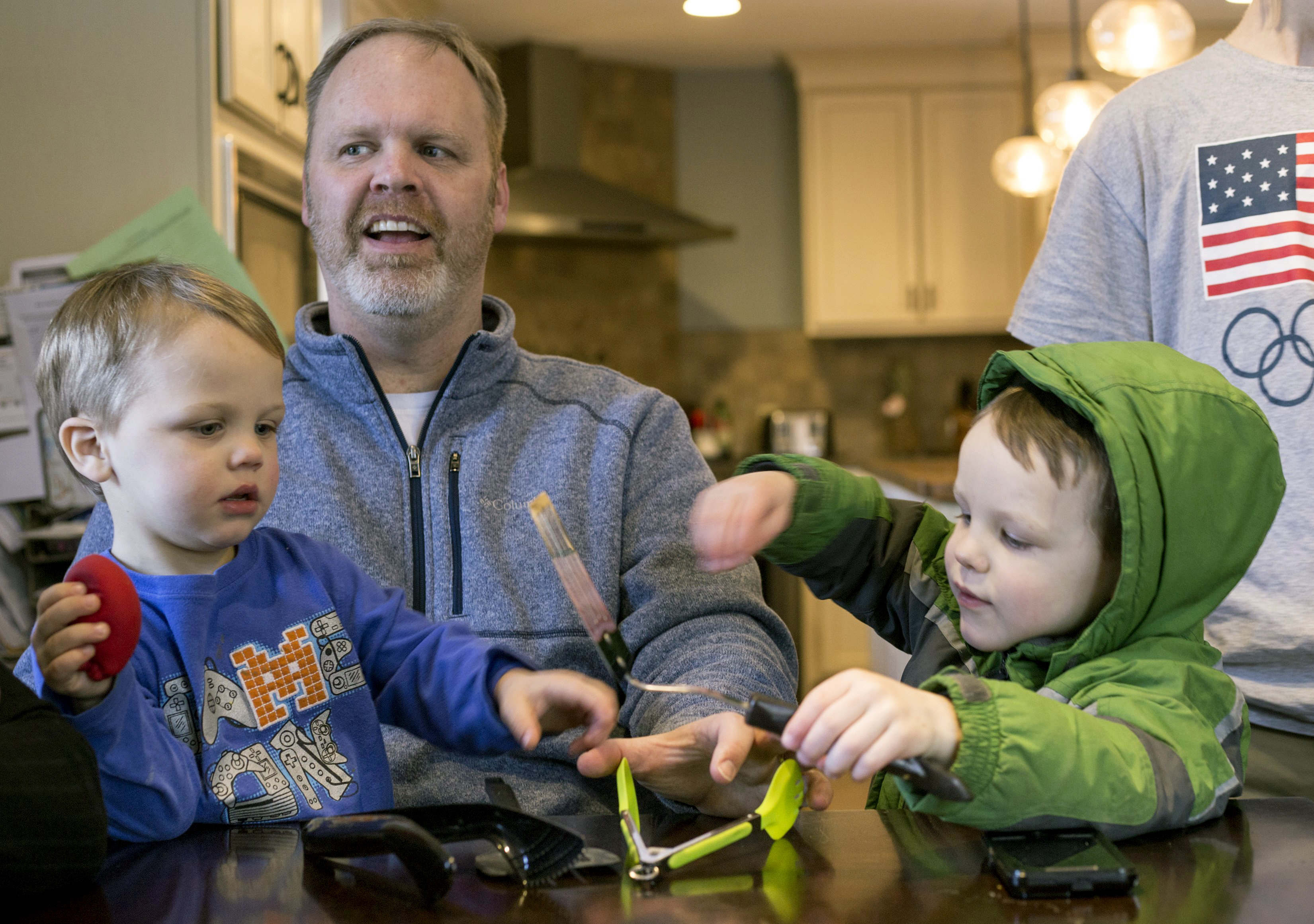 In this Friday, Feb. 16, 2018 photo, Francisco, 2, and Tucker, 4, play as their dad, Jay, is interviewed in their home in Grand Rapids, Mich. The Schwandt family has 13 sons and have welcomed a 14th into the family. The couple's latest addition was born Wednesday evening, April 18 five days before the baby's expected due date. (Casey Sykes, The Grand Rapids Press via AP)