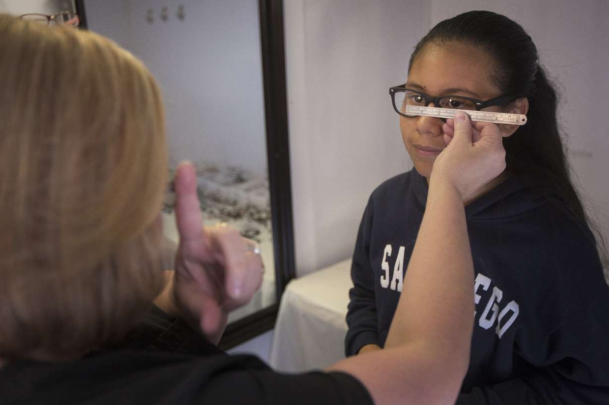 Optician Tawna O'Reilly, of West Valley City, helps Paola Rodriguez, of West Valley City, 10, with her glasses during Eye Care 4 Kids’ mobile clinic event outside Merit Medical on Saturday, April 21, 2018, in South Jordan. (Photo: Jacob Wiegand, KSL)