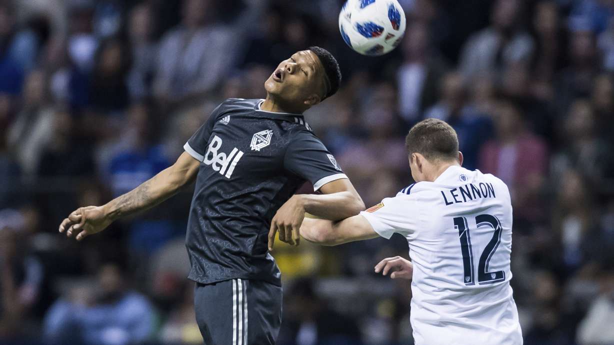 Vancouver Whitecaps' Anthony Blondell, left, gets his head on the ball next to Real Salt Lake's Brooks Lennon during the second half of an MLS soccer match Friday, April 27, 2018, in Vancouver, British Columbia. (Darry Dyck/The Canadian Press via AP)